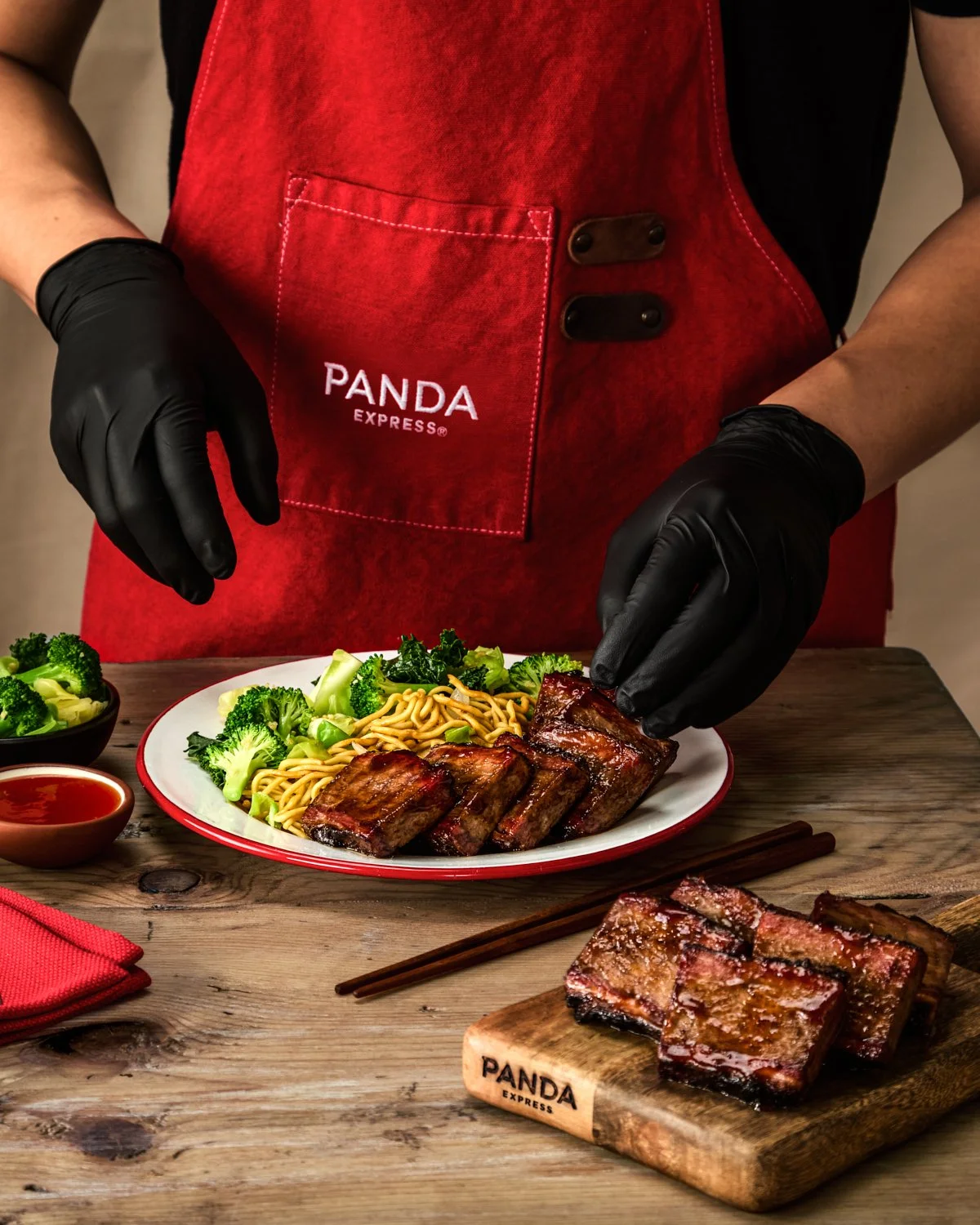 Panda Express Cantonese BBQ Brisket served in a branded takeout box with broccoli and dipping sauce for commercial food photography.
