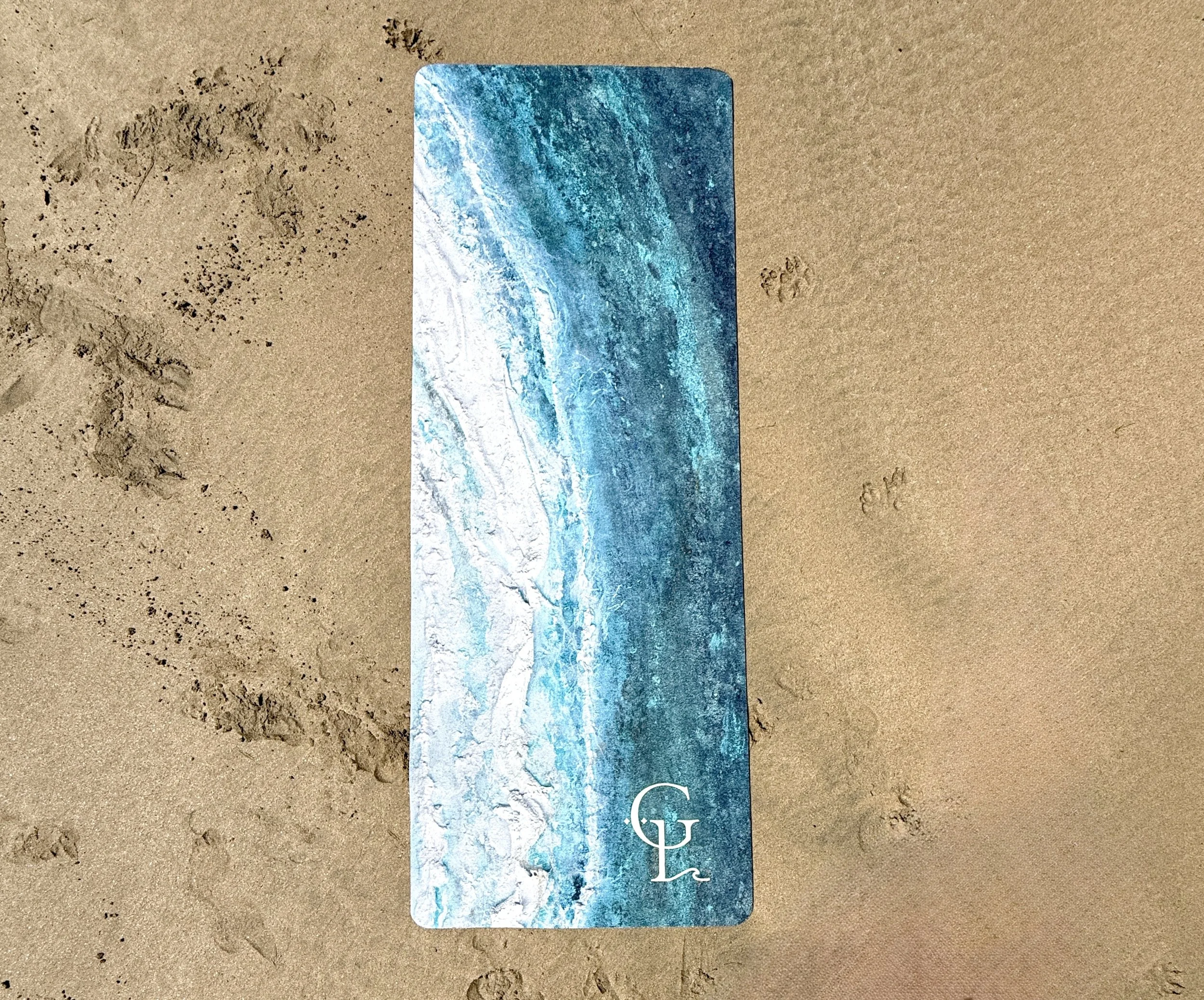 'Swell off Shore at Fistral' yoga mat by Gemma Lessinger, shown on Fistral beach in the sand