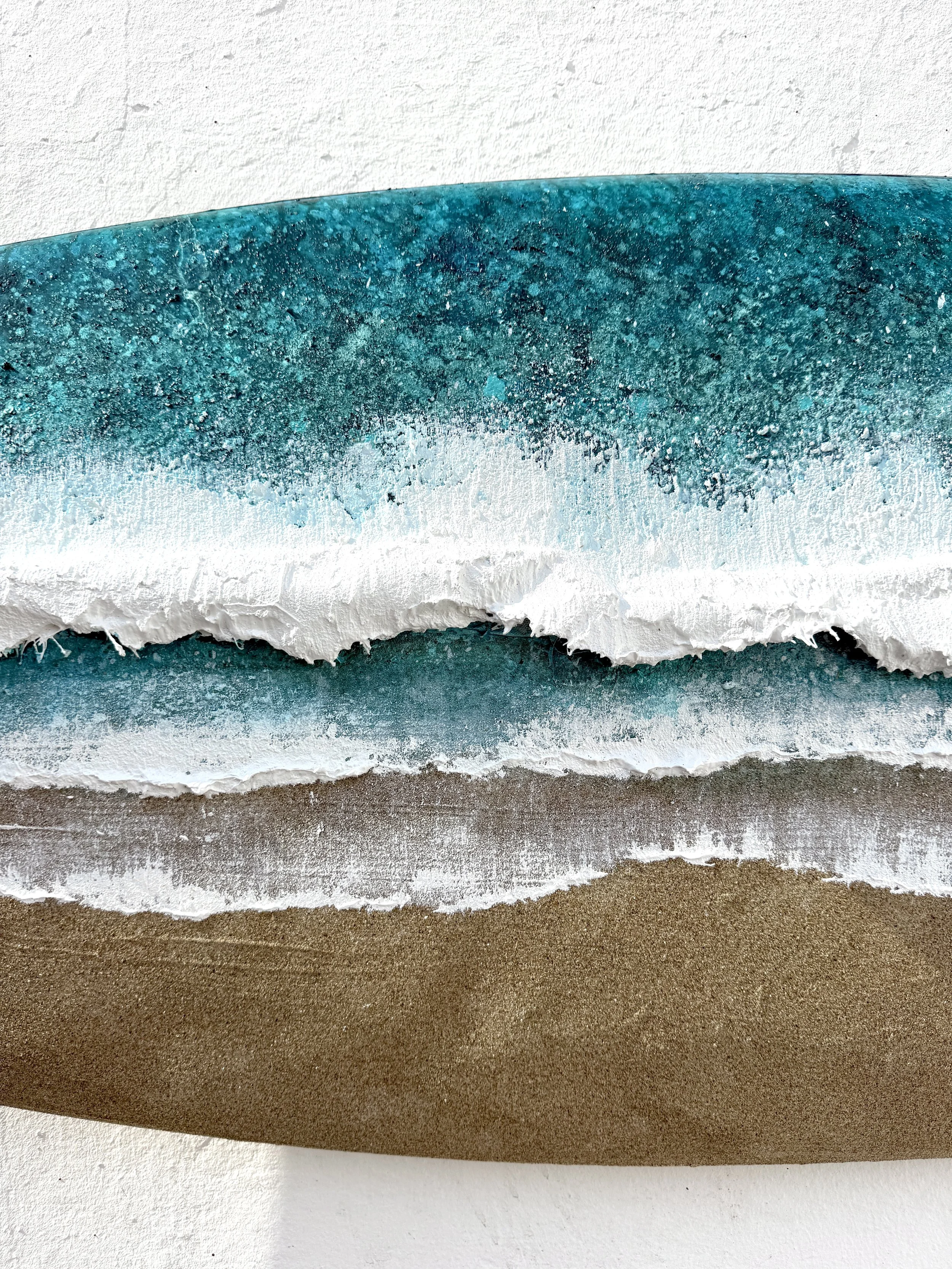 Close-up of Fistral Surf surfboard painting showing fibreglass wave texture