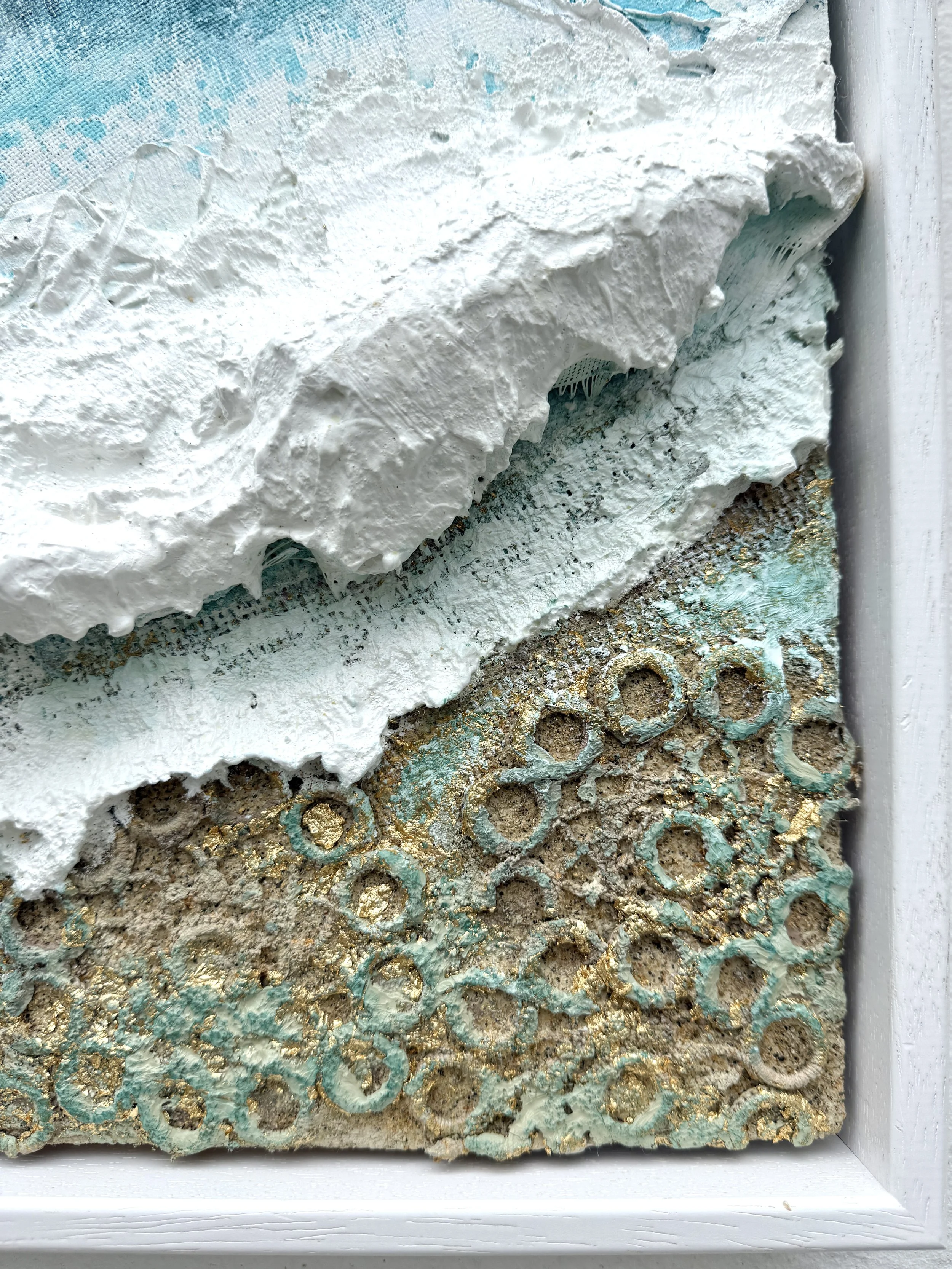Close-up of lace doily rings and gold leaf in the sand of Washed in Gold