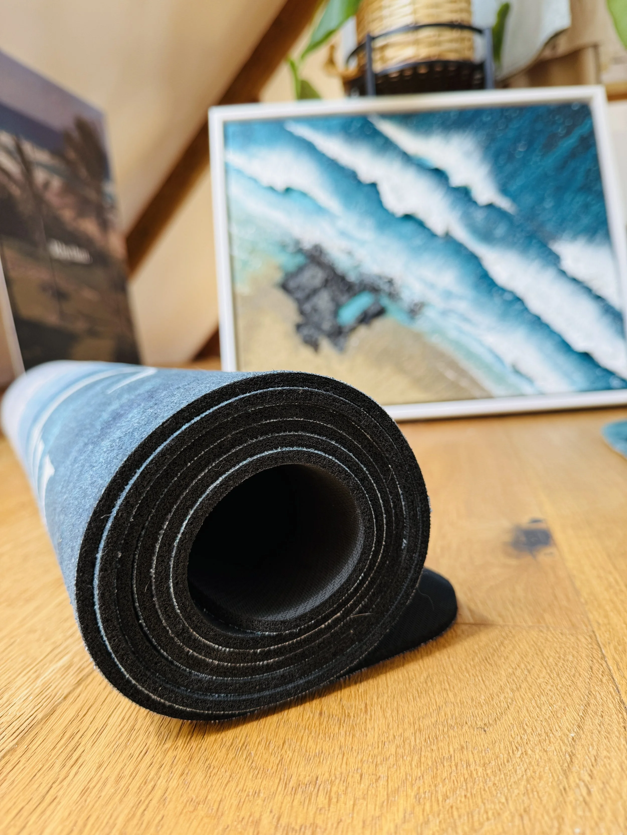 Gemma Lessinger, Cornish seascape artist, in her studio with an ocean-inspired original painting and yoga mat