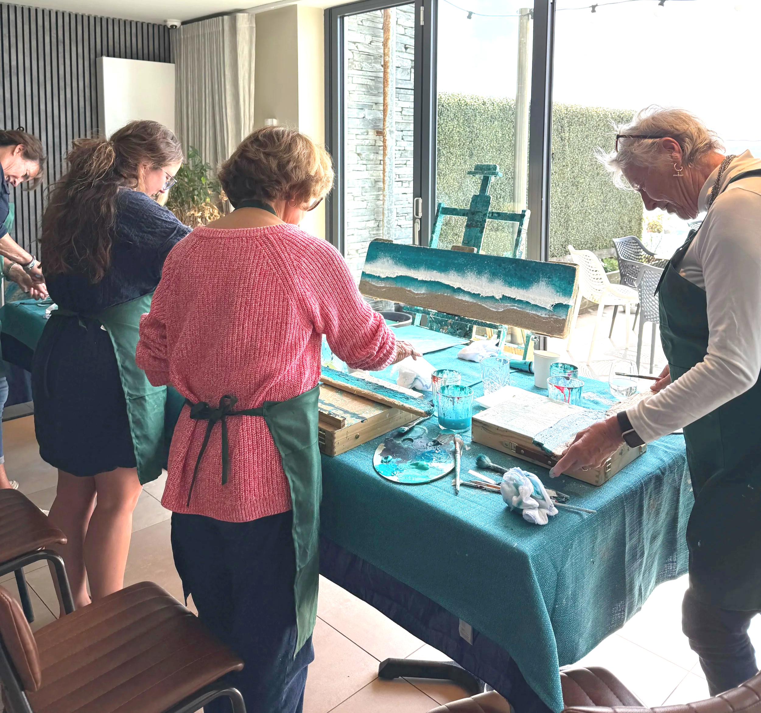 Participant creating a driftwood seascape painting at Driftwood & Tide workshop