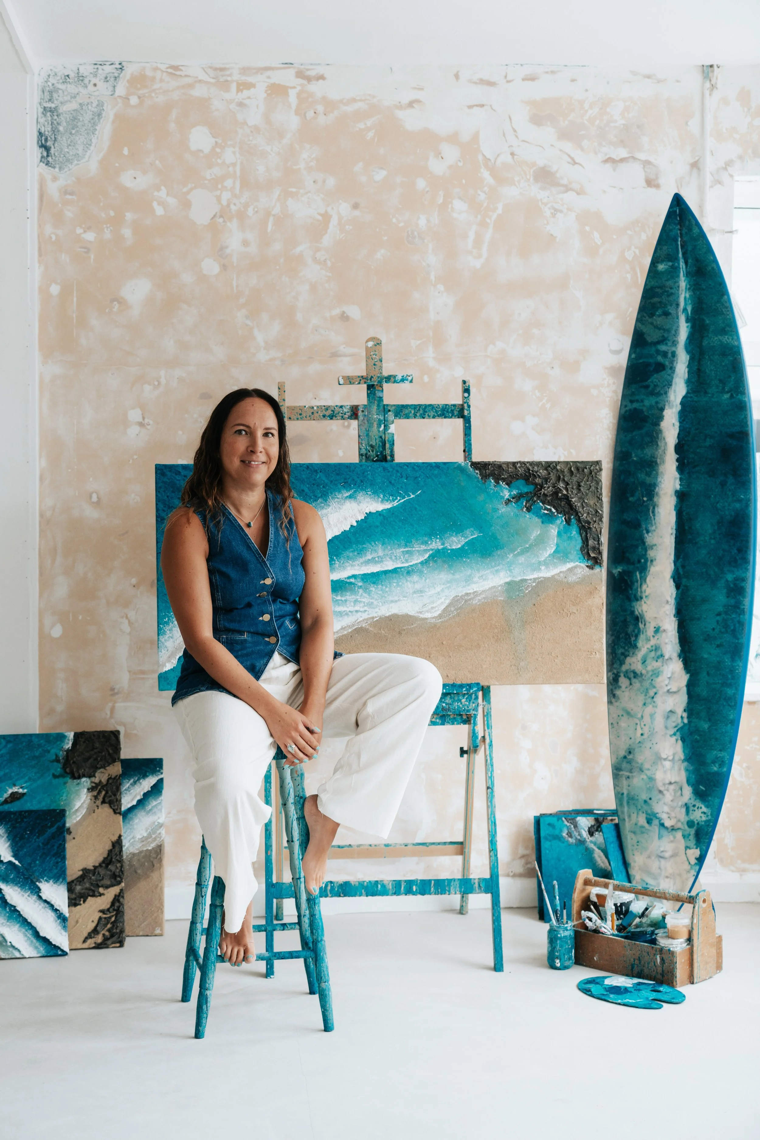 Gemma Lessinger in studio with seascape paintings
