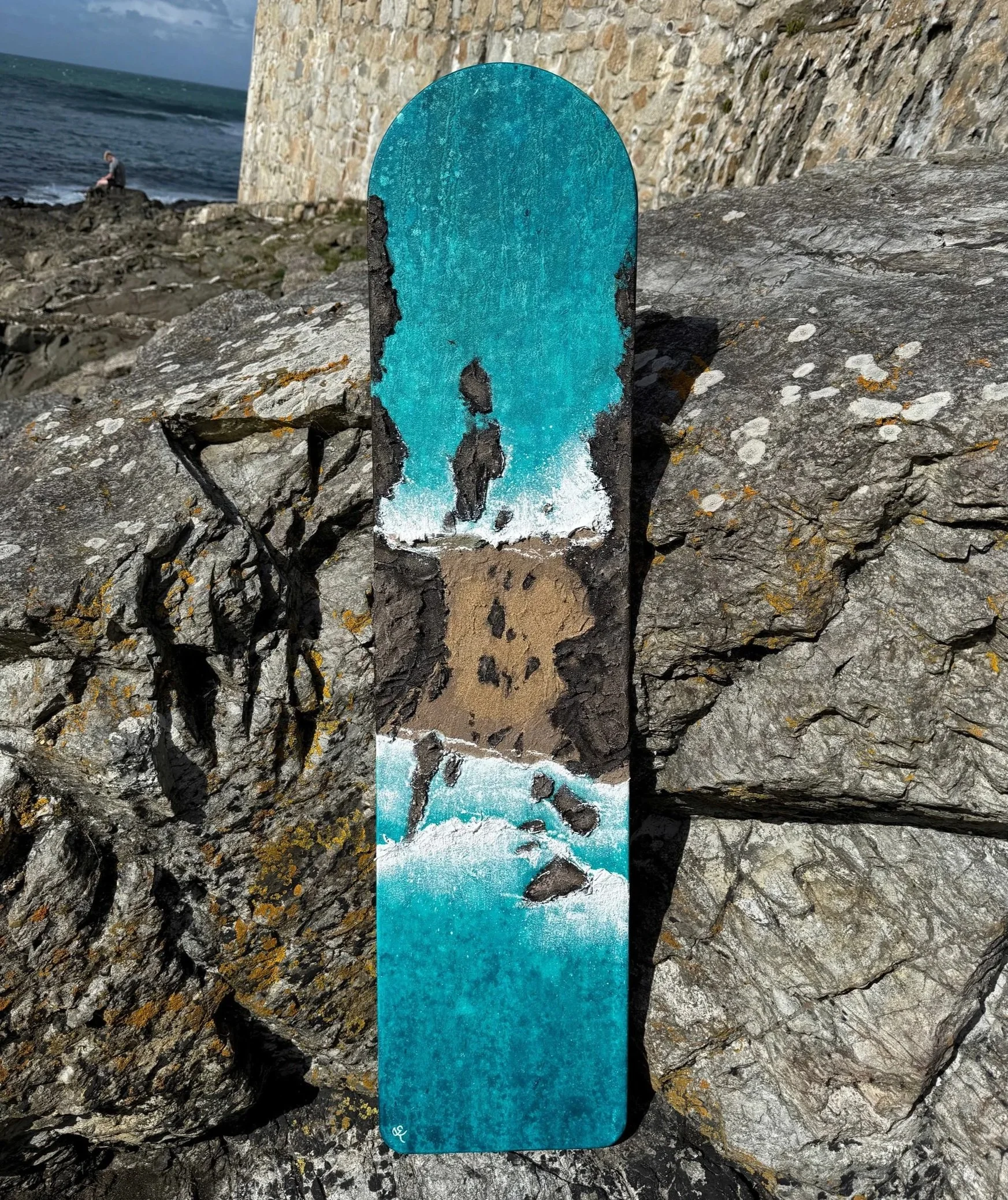 Textured seascape painting onto a wood bellyboard sown on the rocks on Kynance Cove beach in Cornwall