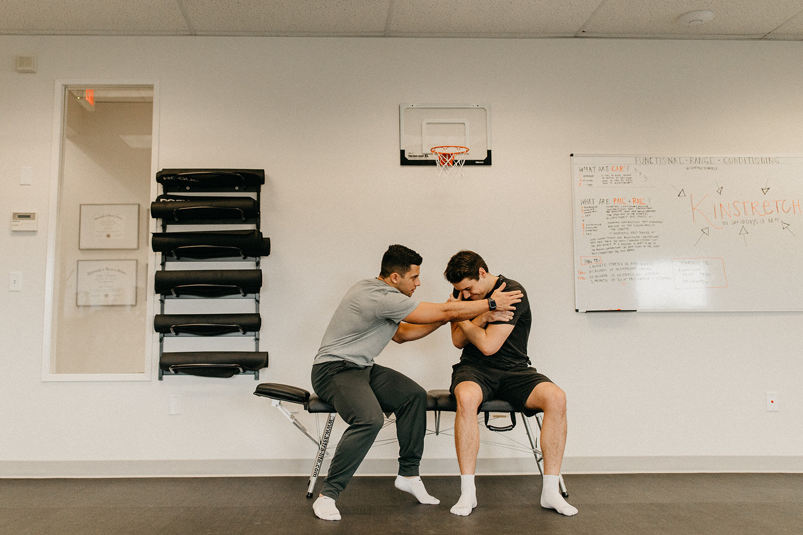 A Mobility Specialist at Northwest Spine and Sport helping a patient engage in a spinal stretch.