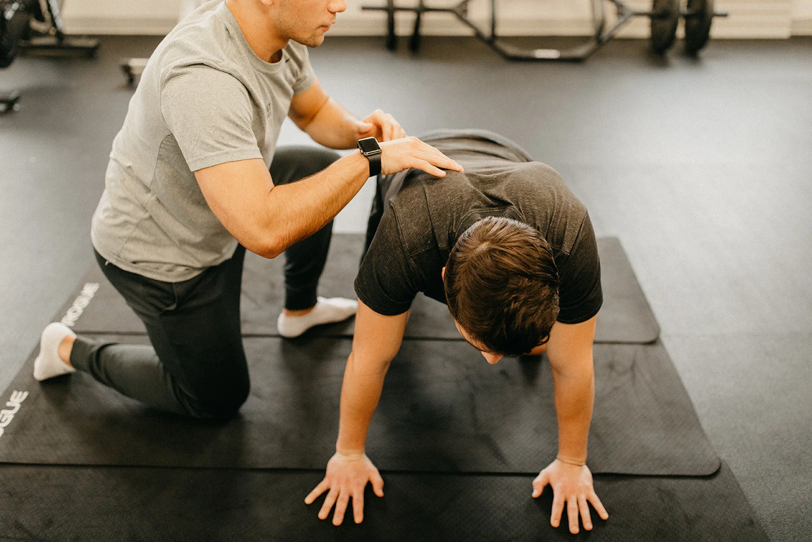 A Mobility Specialist at Northwest Spine and Sport helping a patient engage in a lower back stretch.