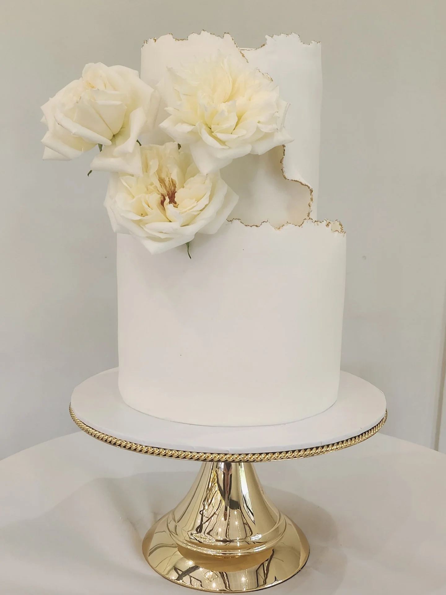 For Grace &amp; Brock, I created this two-tier beauty in white chocolate raspberry and caramel, wrapped in delicate textured fondant with hand-painted gold edging for that luxe finish.

Perched perfectly at @Bimbadgenpalmerslane and adorned with roma