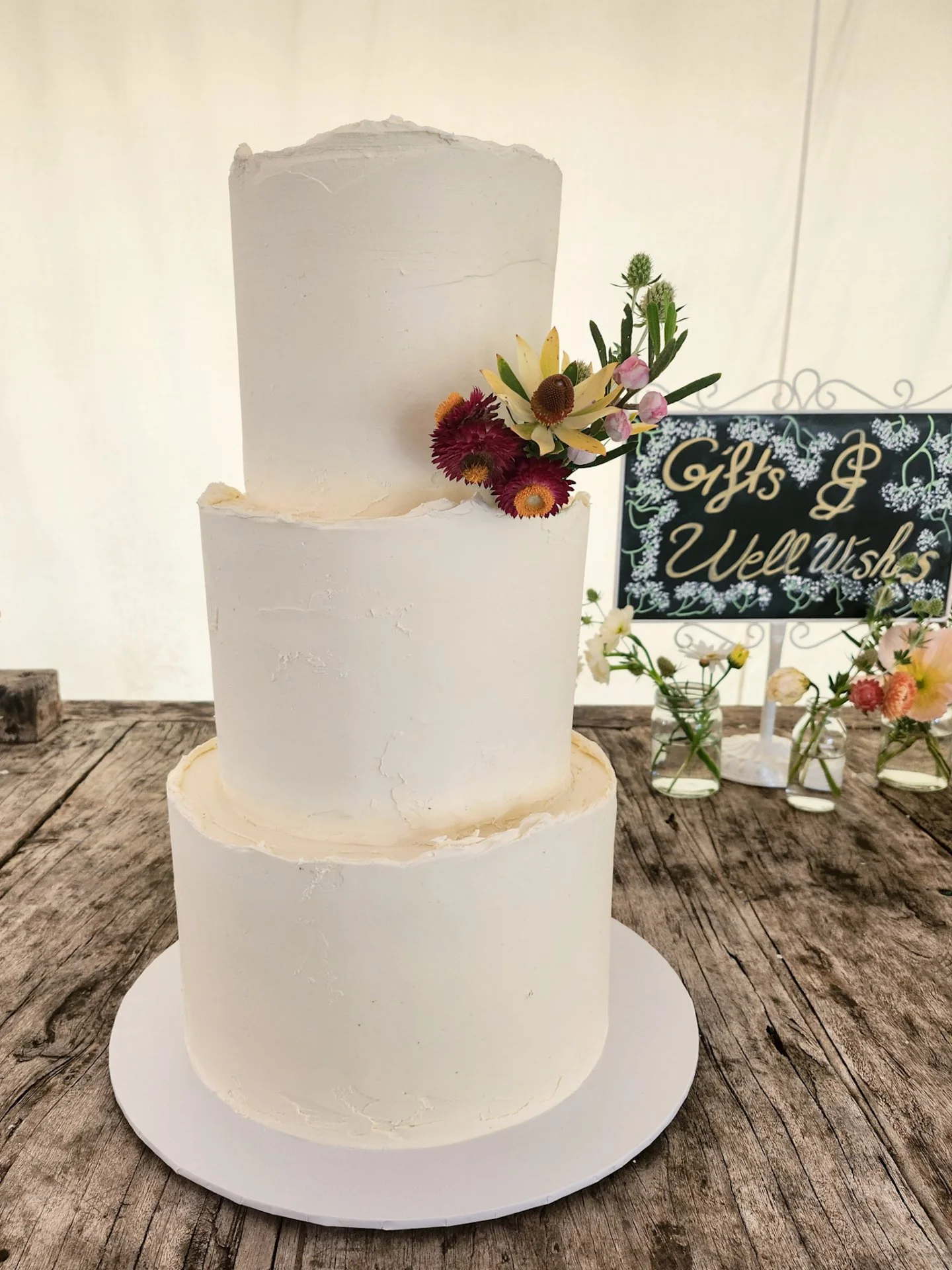 A stunning 3-tier white ganache cake in flavourful mango, coconut + caramel for Hollie &amp; Ellie&rsquo;s big day, finished with soft texture &amp; uneven top edges for that effortlessly modern feel.
 
A dreamy, modern twist on a classic tiered cake