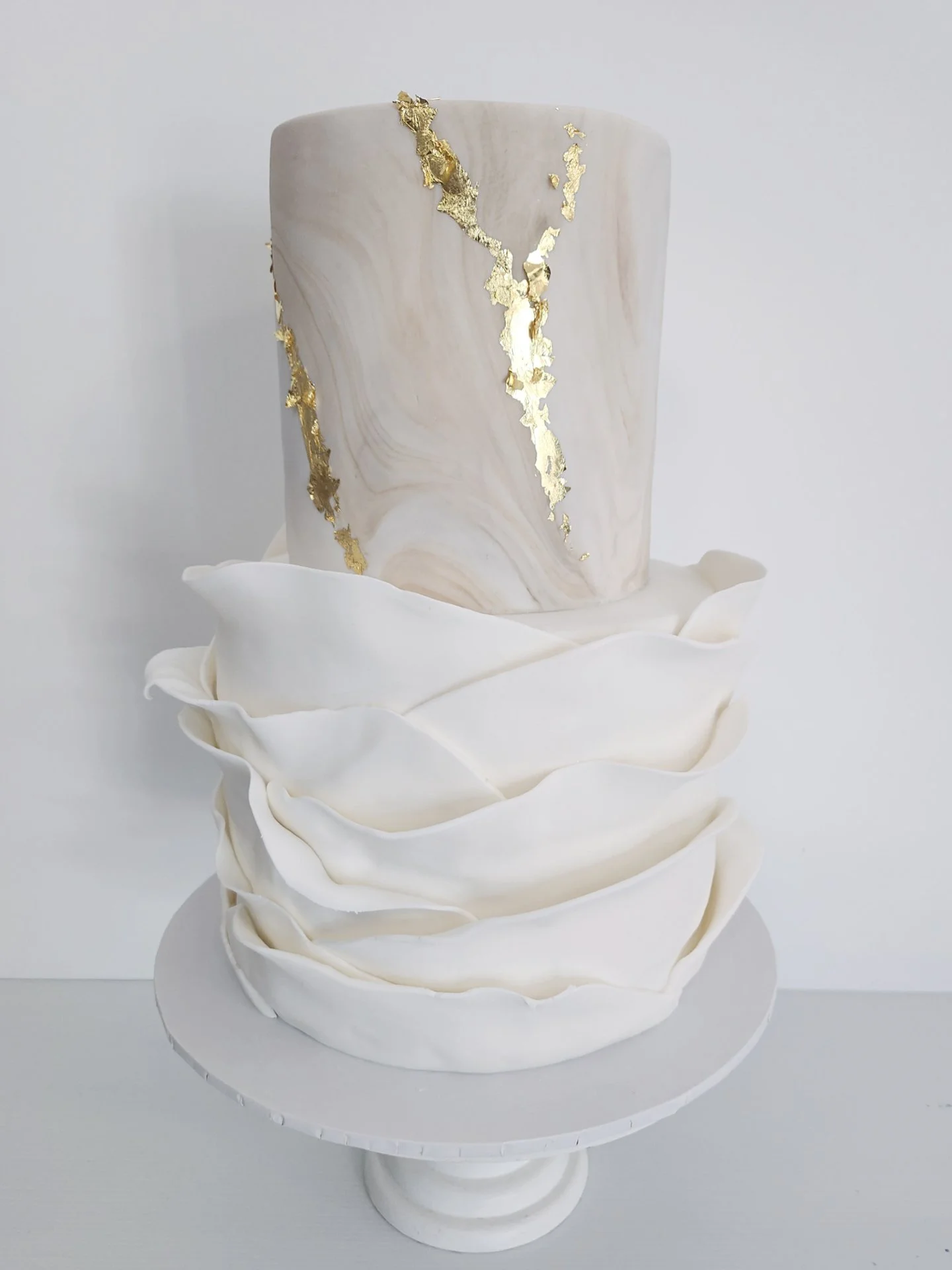 Swipe to add a topper 👉

This two-tier fondant beauty for Tania &amp; Michael featured bandage ruffles, a marbled tierr with gold leaf accents.✨

Inside? Yummy chocolate and white chocolate raspberry, a winning combo!

📍 @willowtreeestate
💐 @jadem