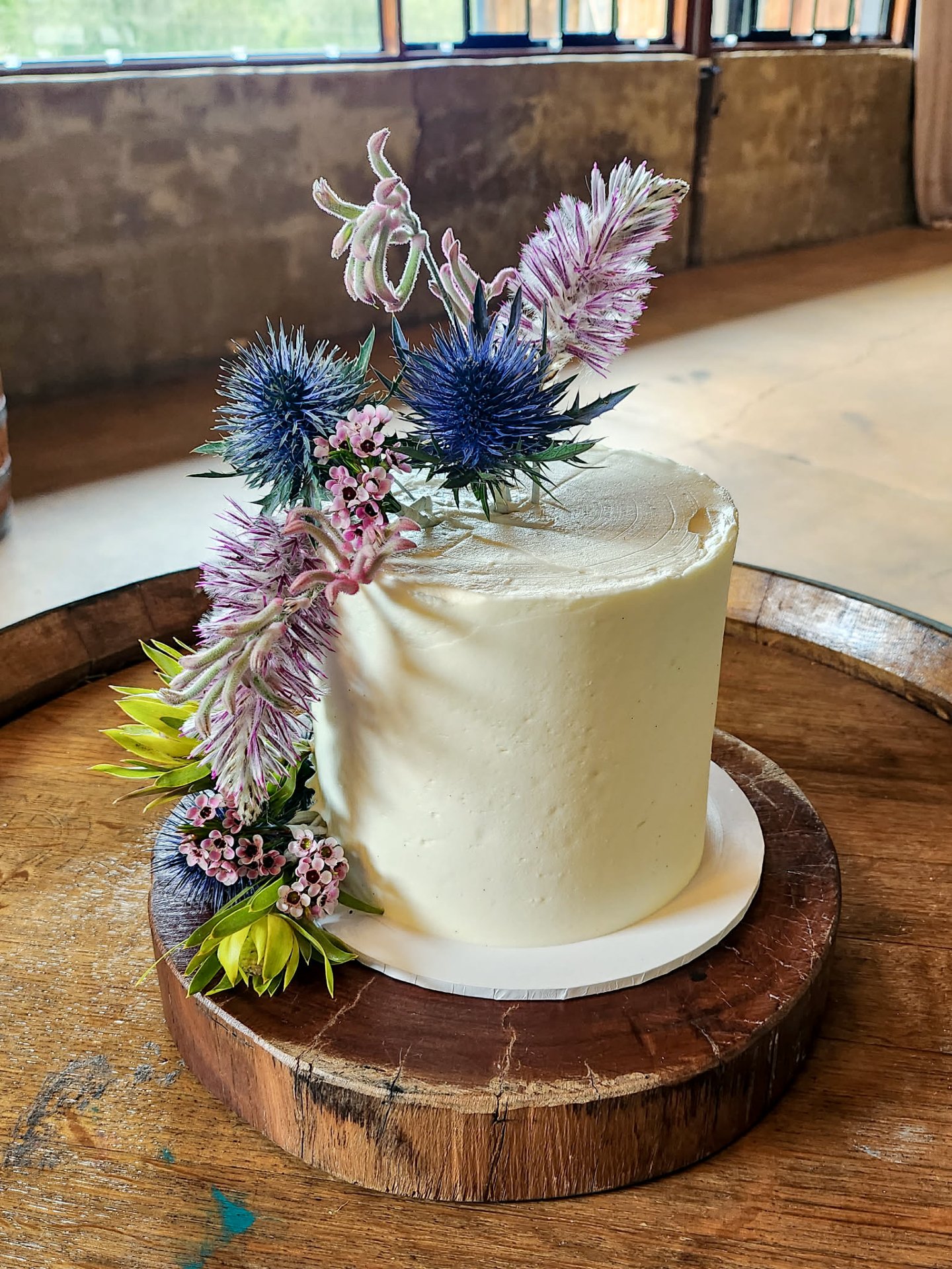 Kirstan &amp; Daniel&rsquo;s @pashanddash delight! 💜

A single tier of smooth white buttercream in delicious chocolate paired with 27 chocolate cupcakes.

Topped with beautiful blooms by @jademcintoshflowers &amp; held in the stunning @pepperscreek_