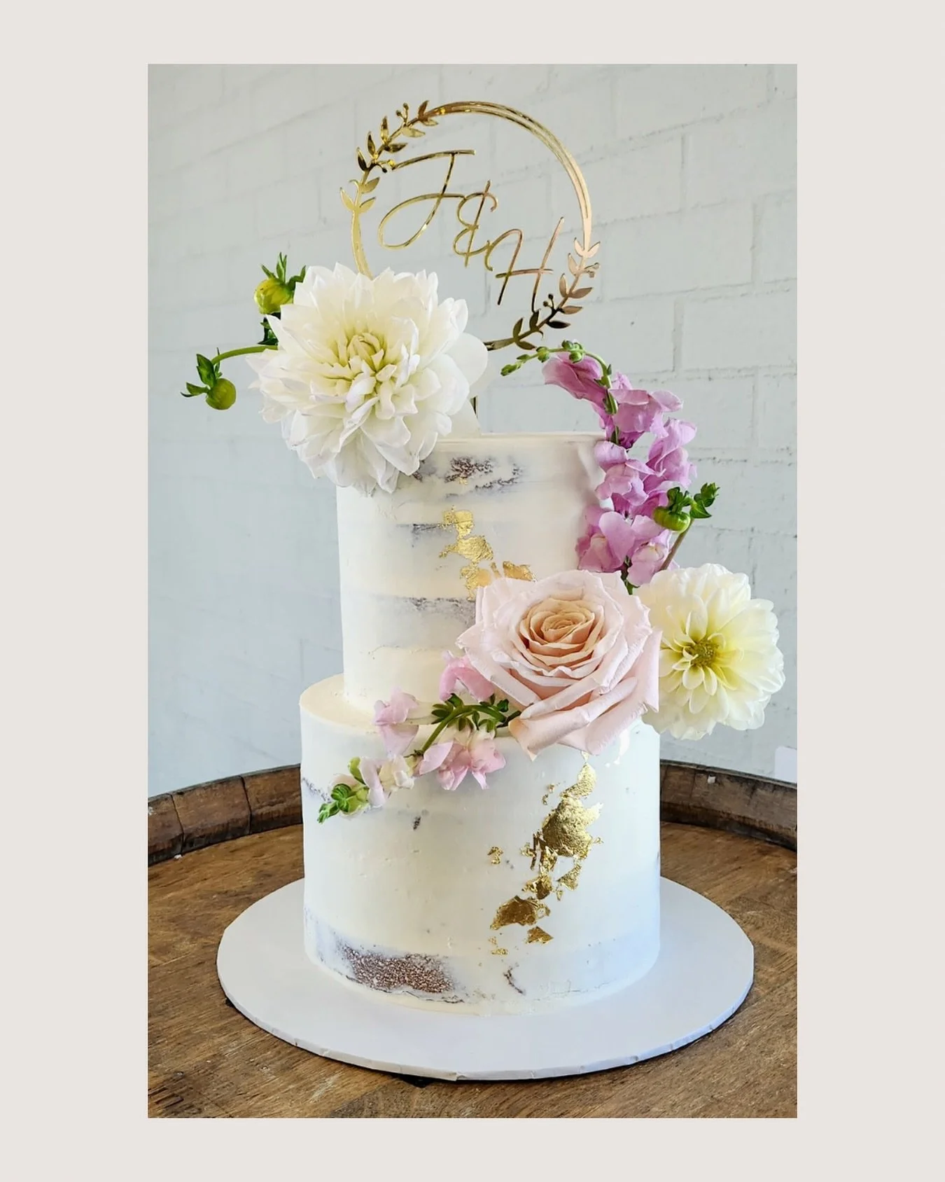 Hannah &amp; Jonathon delicious 2 tier semi naked cake in delicious caramel with white chocolate ganache and strawberry, dressed in gold leaf accents and a custom topper. ✨

Paired with the most beautiful florals by @theposygarden 🌸

📍 @bimbadgenpa