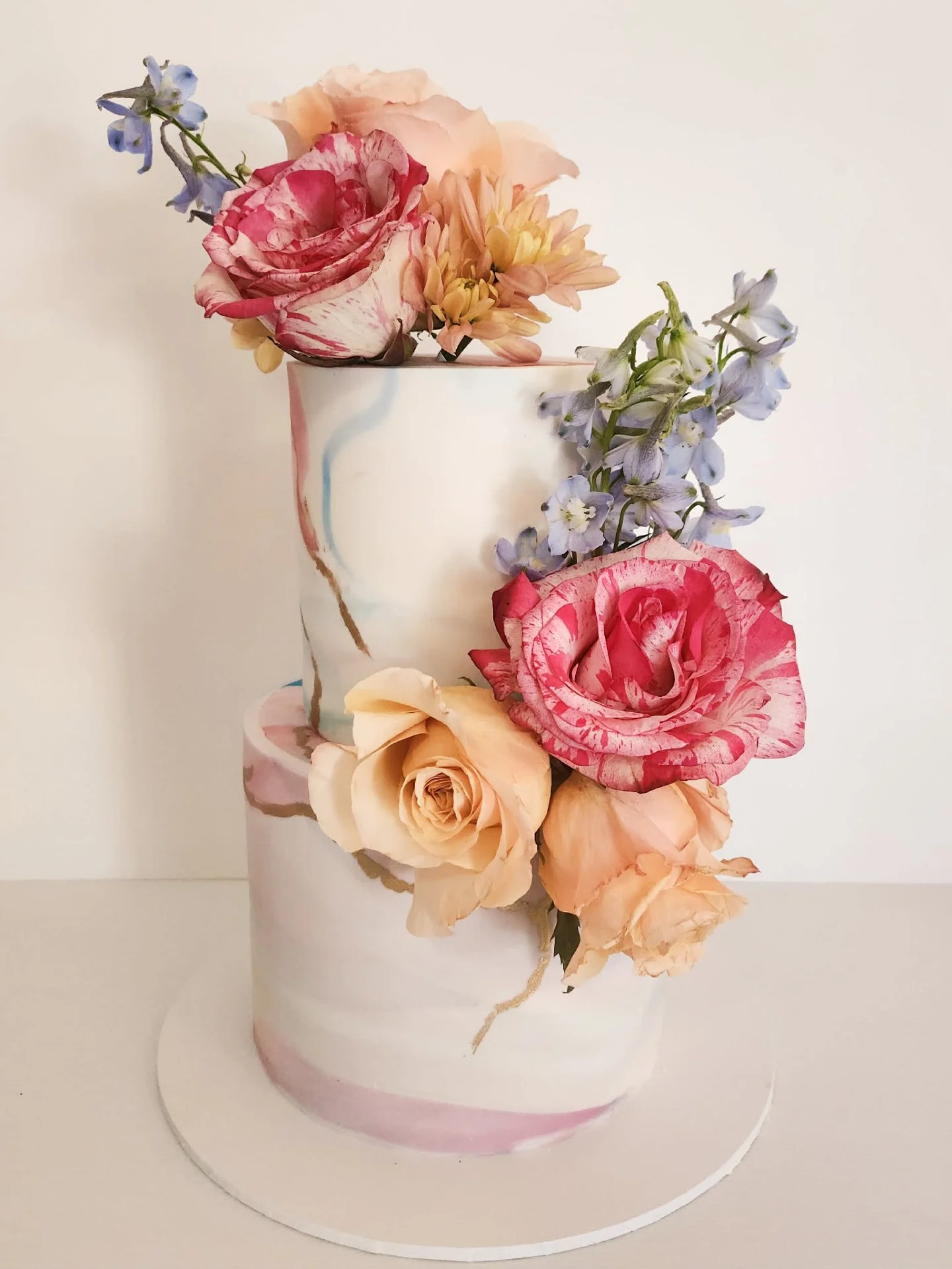 Bold. Bright. Absolutely beautiful 🌸✨

This two tier white chocolate fondant cake features the most stunning bright marble design across both tiers, paired with fresh flowers in the most gorgeous colour palette. 

🌺 @beautifulbloomsofkurri 

#Event