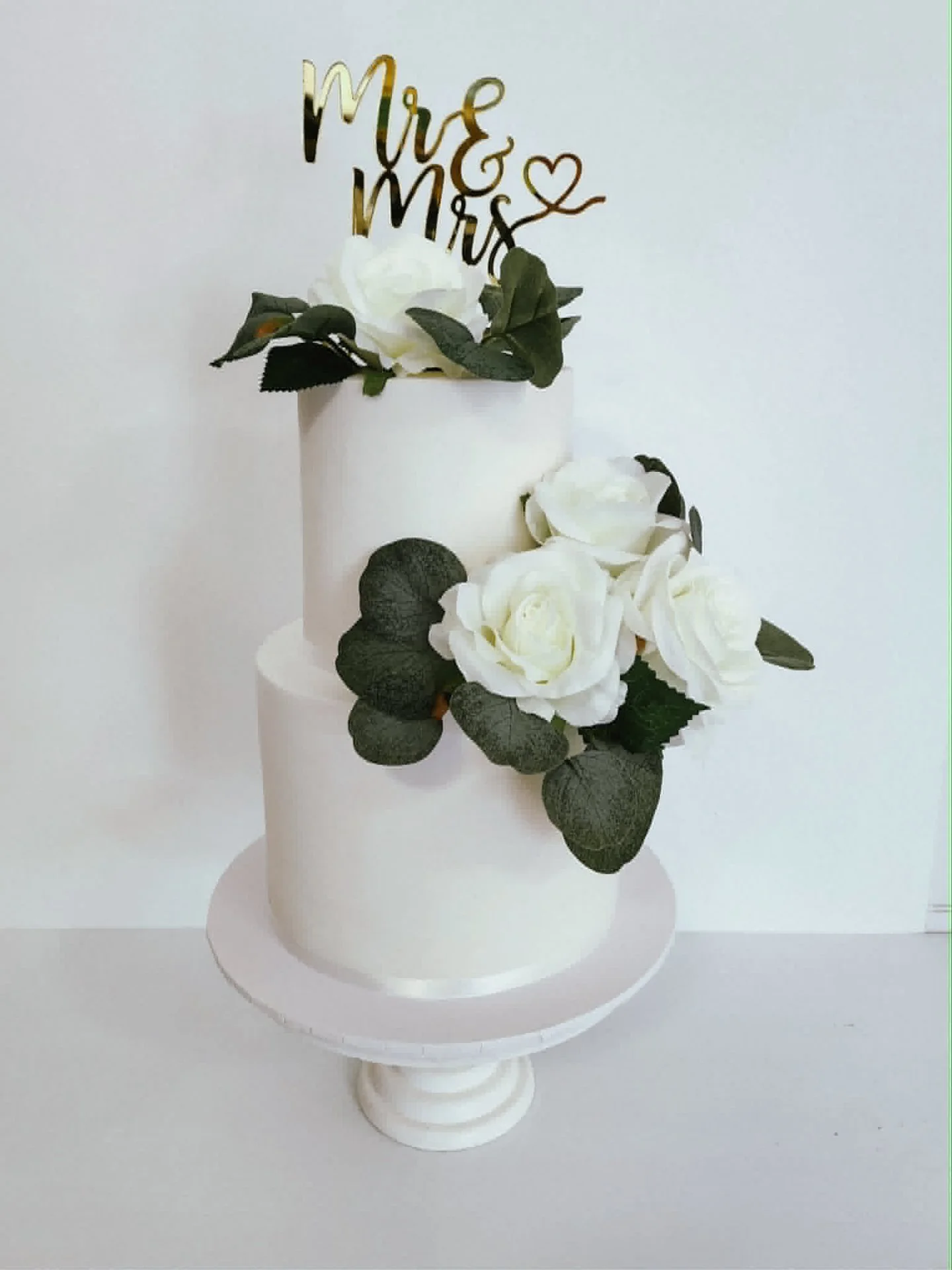 Clean lines. White roses. Deep green foliage. That gold topper ✨

Clinton &amp; Julia's two tier white fondant cake was the definition of understated elegance and I loved every bit of creating it. 🤍🌿

Celebrated in style at the gorgeous @qtnewcastl