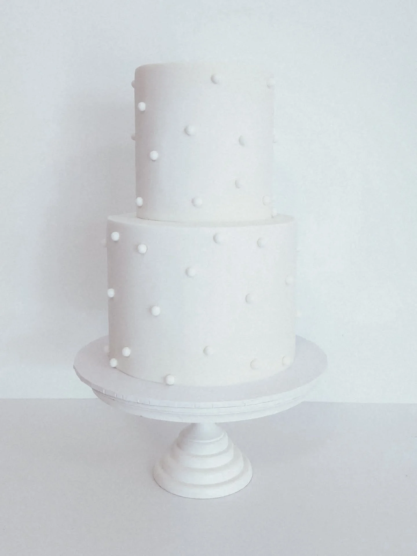 Let the details do all the talking ✨

Two tiers of chocolate cherry coconut and white chocolate in the crispest white fondant, each sugar pearl hand-placed with so much love for Lucy &amp; Kieran.🤍 

📍 @petersonhouseweddings

#dragonflycakes #hunte