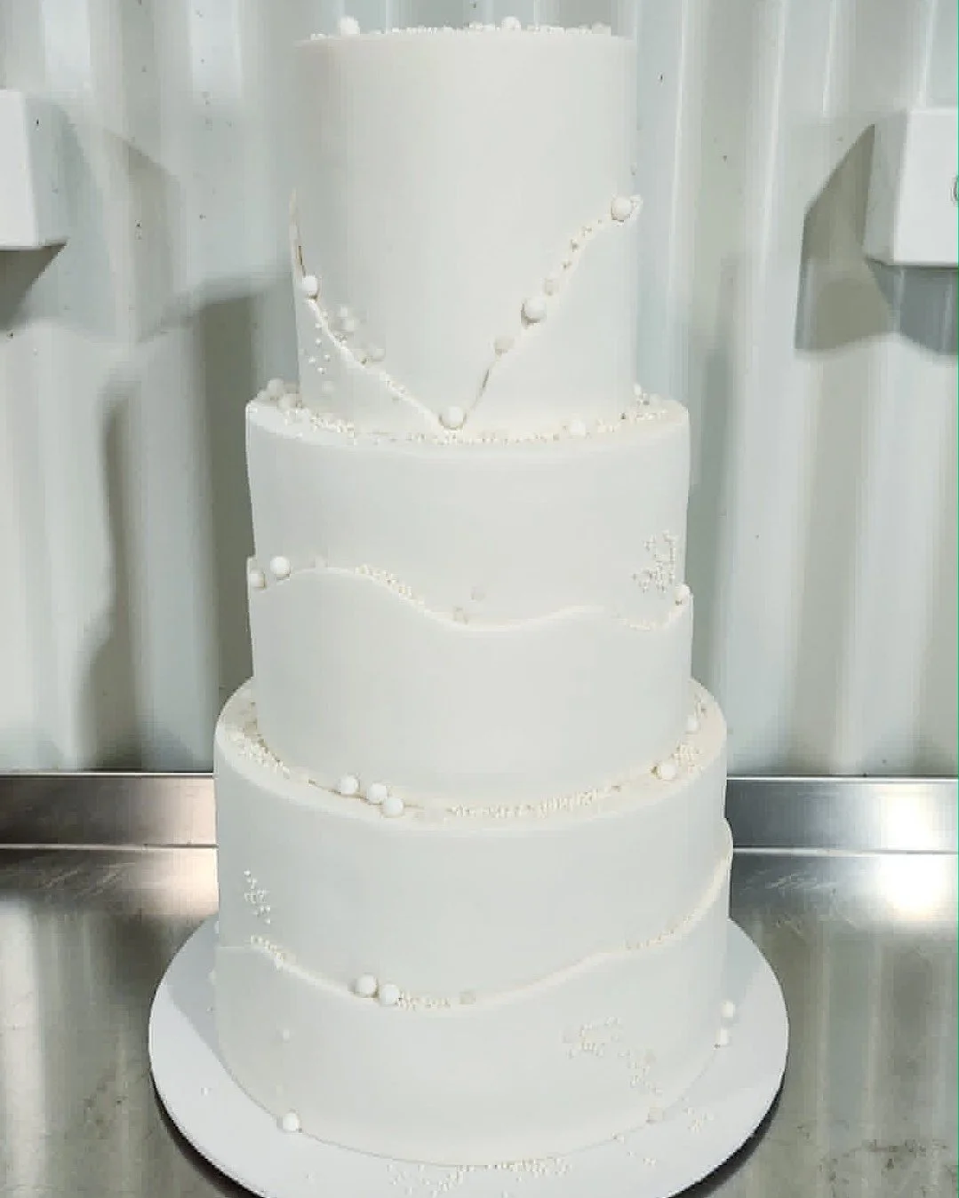 Three tiers of pure elegance, red velvet and white chocolate raspberry beneath the most stunning all-white fondant finish for Jillian &amp; Mitchell. 🤍✨

Those flowing fondant wraps and scattered pearl details have my heart completely 😍

Understate