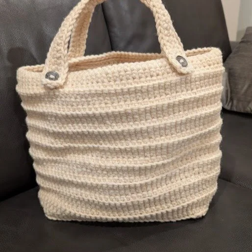 I received pure undyed wool from a friend. The yarn was too bulky for a sweater and probably too itchy as well. I used up every last bit of wool to crochet this bag with a No.7 crotchet hook. The bag, without the straps, measures about 15"w, 13&