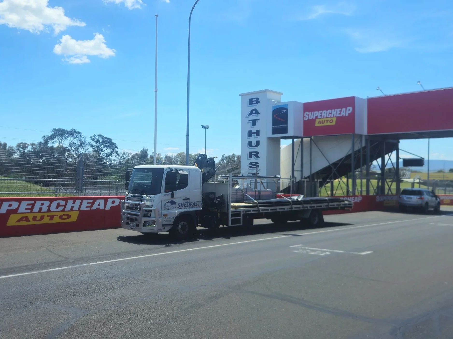 Shedfast DIY shade shed delivery truck parked at Bathurts Mount Panorama race track.