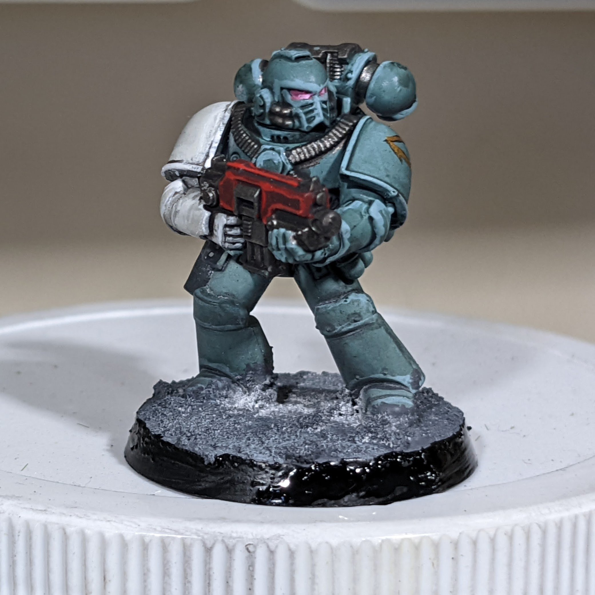 A sons of horus marine with a red bolter and one white arm