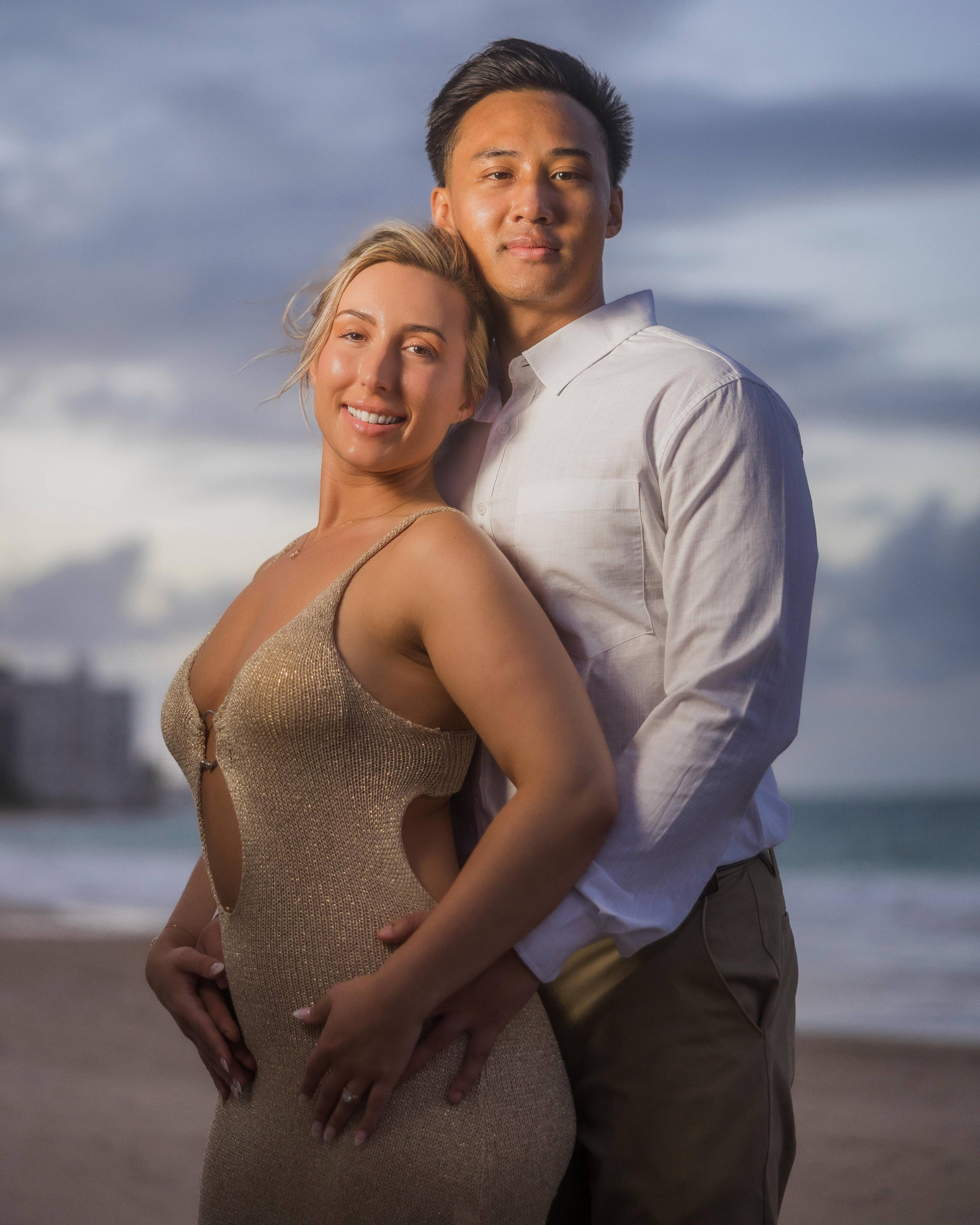 A couple embracing in Puerto Rico during a surprise marriage proposal at the beach.