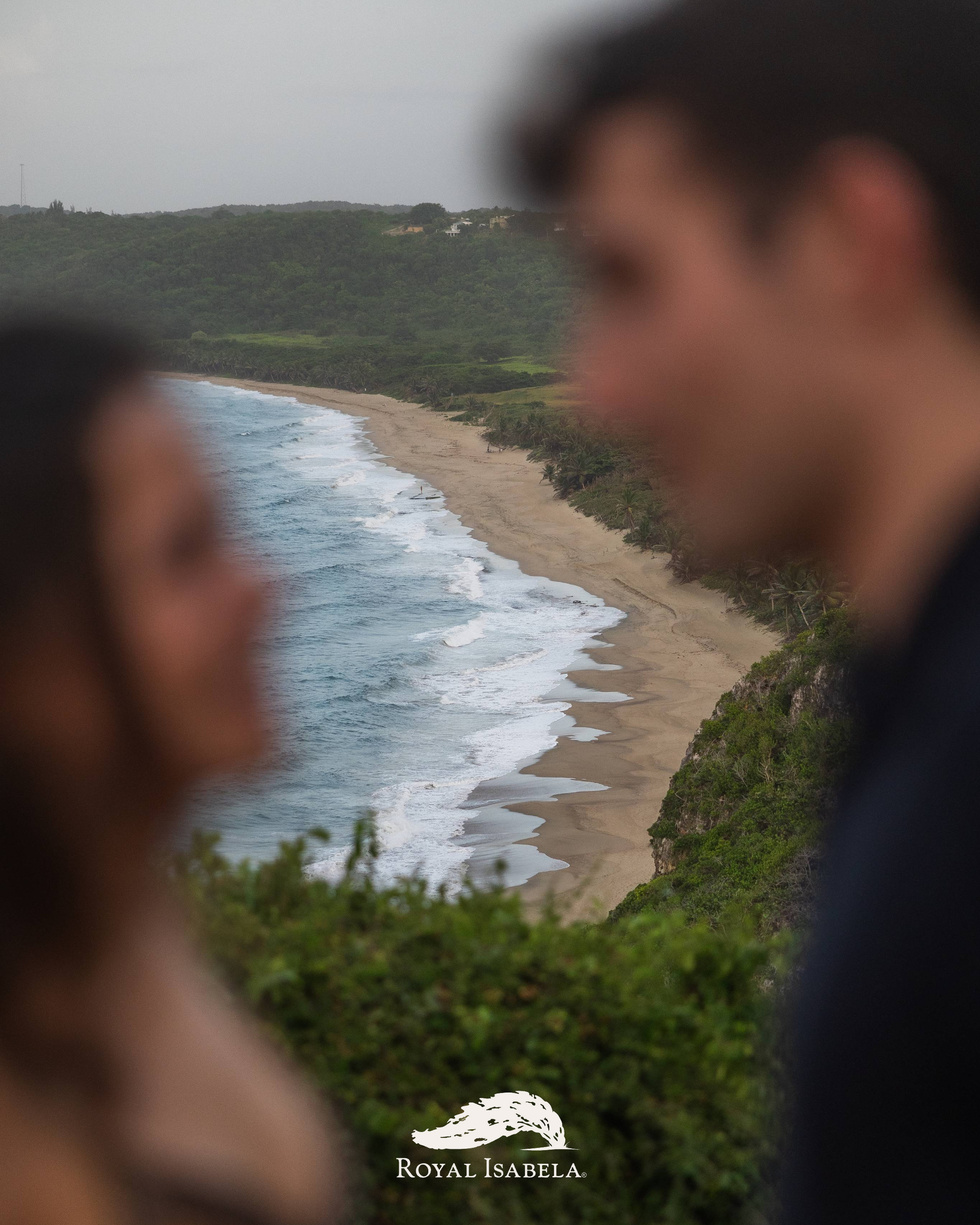 Creative engagement photograph featuring Puerto Rico's coastline framed between an engaged couple at Royal Isabela.