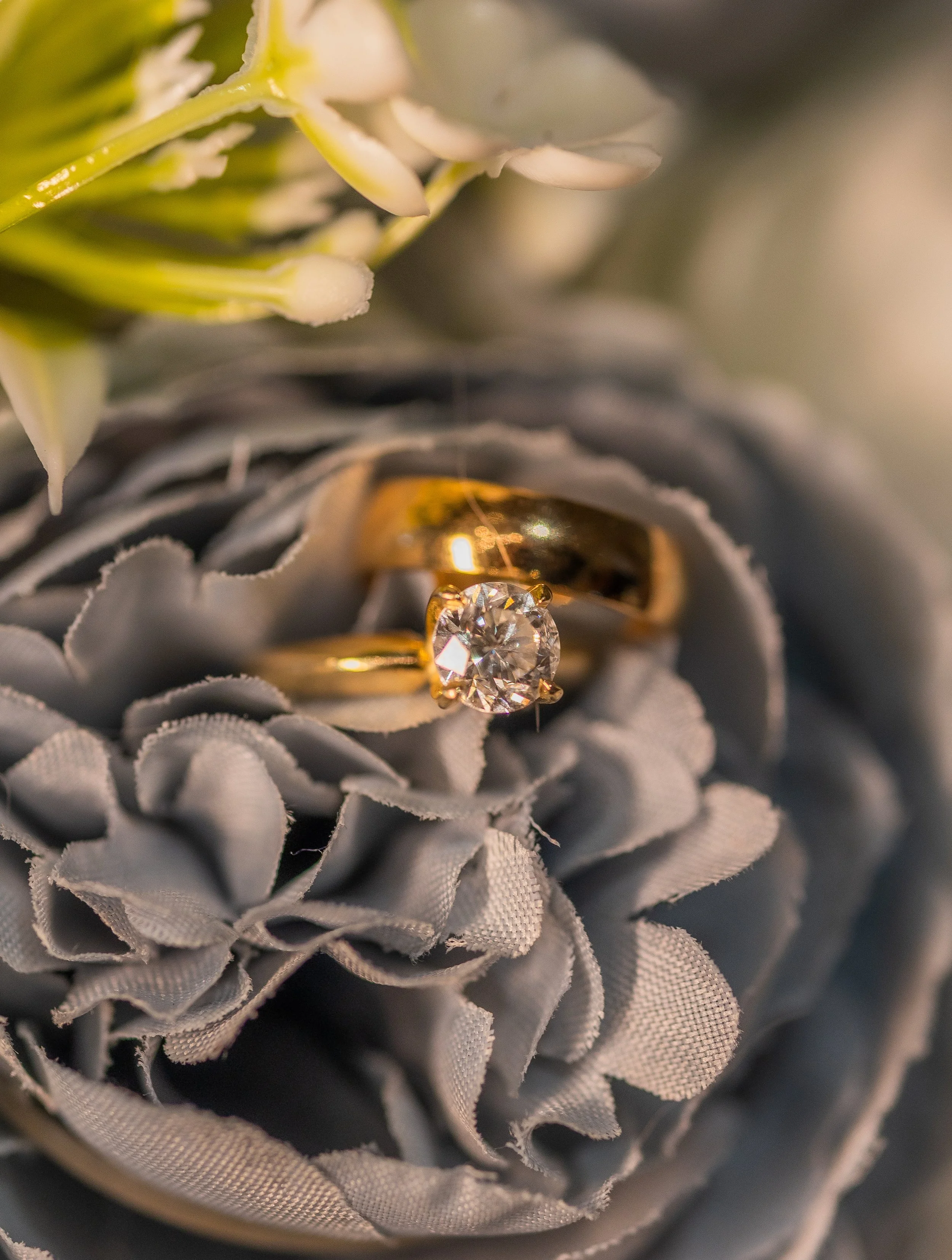 Diamond wedding rings on floral decoration taken by a luxury editorial wedding photographer in South Florida. 