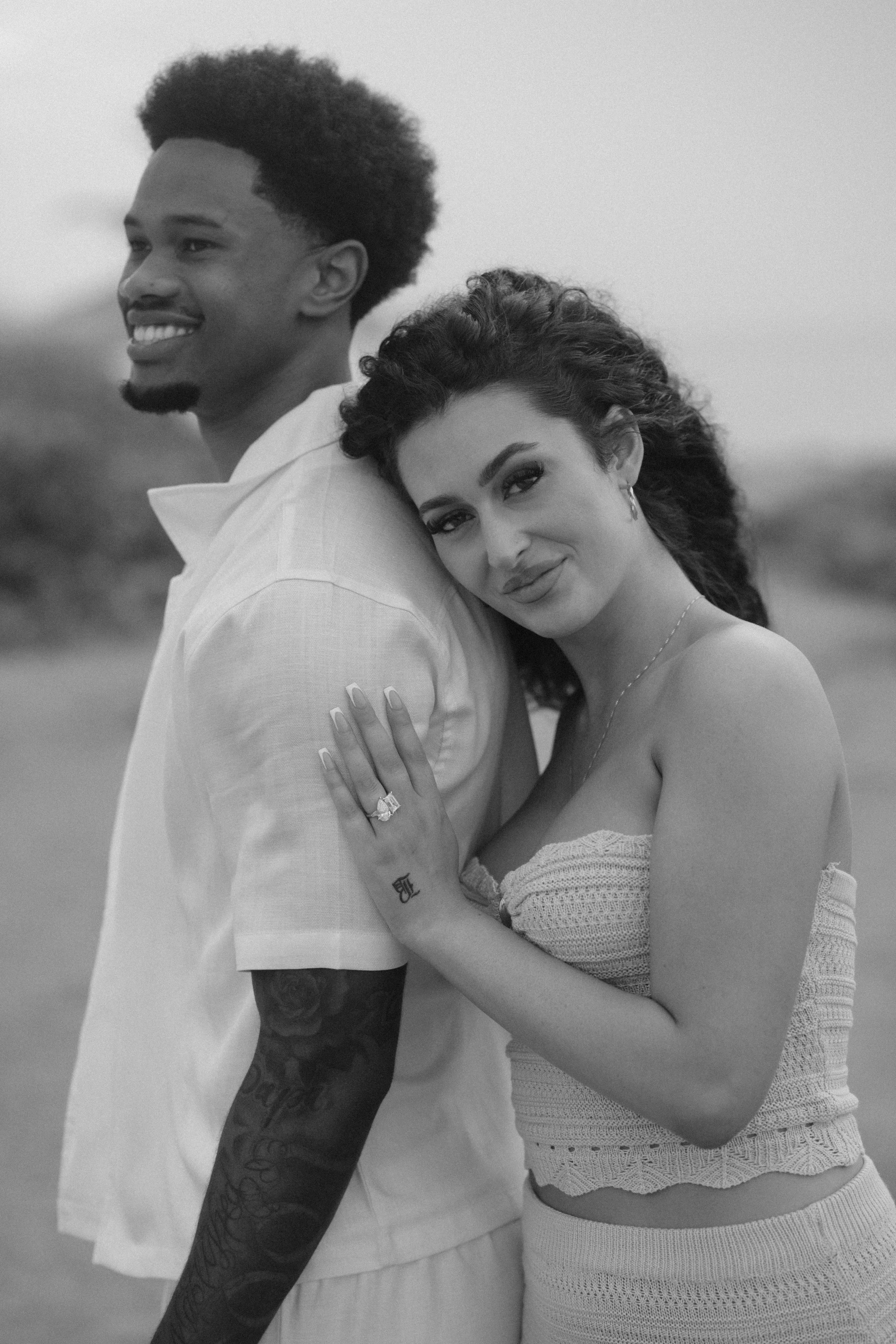 Couple embracing at Escambrón Beach during a surprise marriage proposal in Puerto Rico taken by a luxury wedding photographer