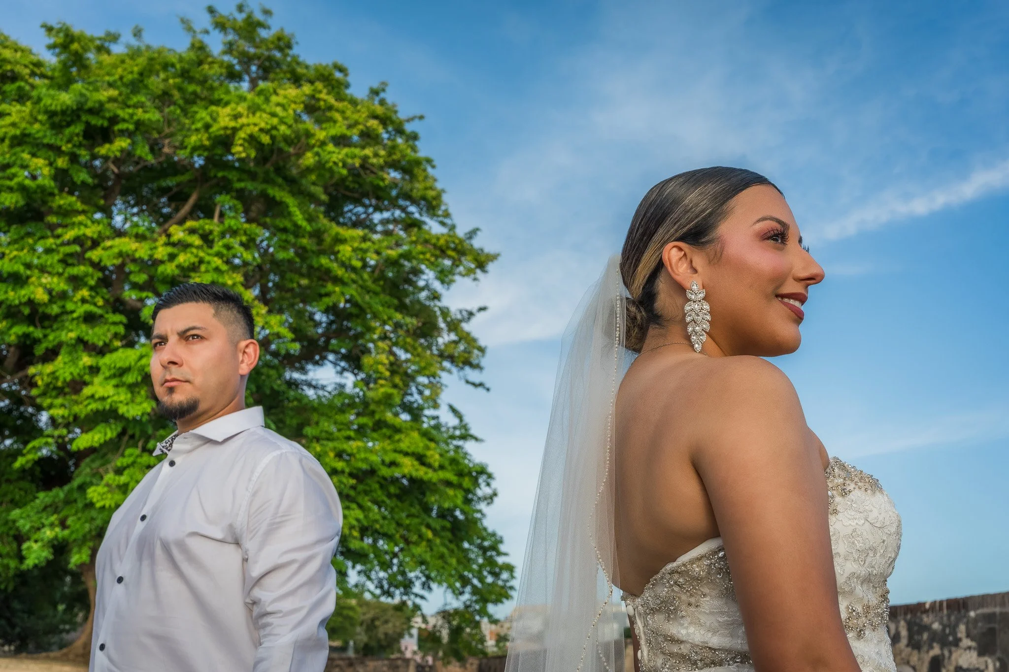 Bride and groom posing together at twilight overlooking the Caribbean Sea after their luxury destination elopement in Old San Juan, Puerto Rico.