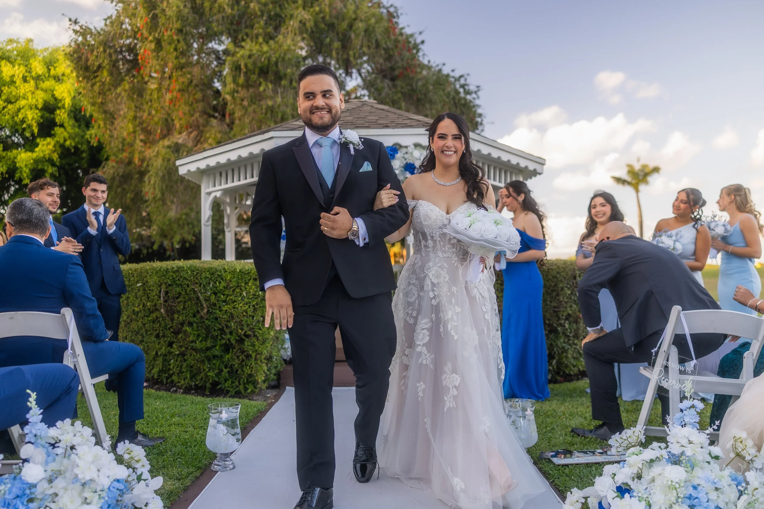 Bride and groom walking down the aisle at Indian Spring Country Club after their luxury wedding ceremony.