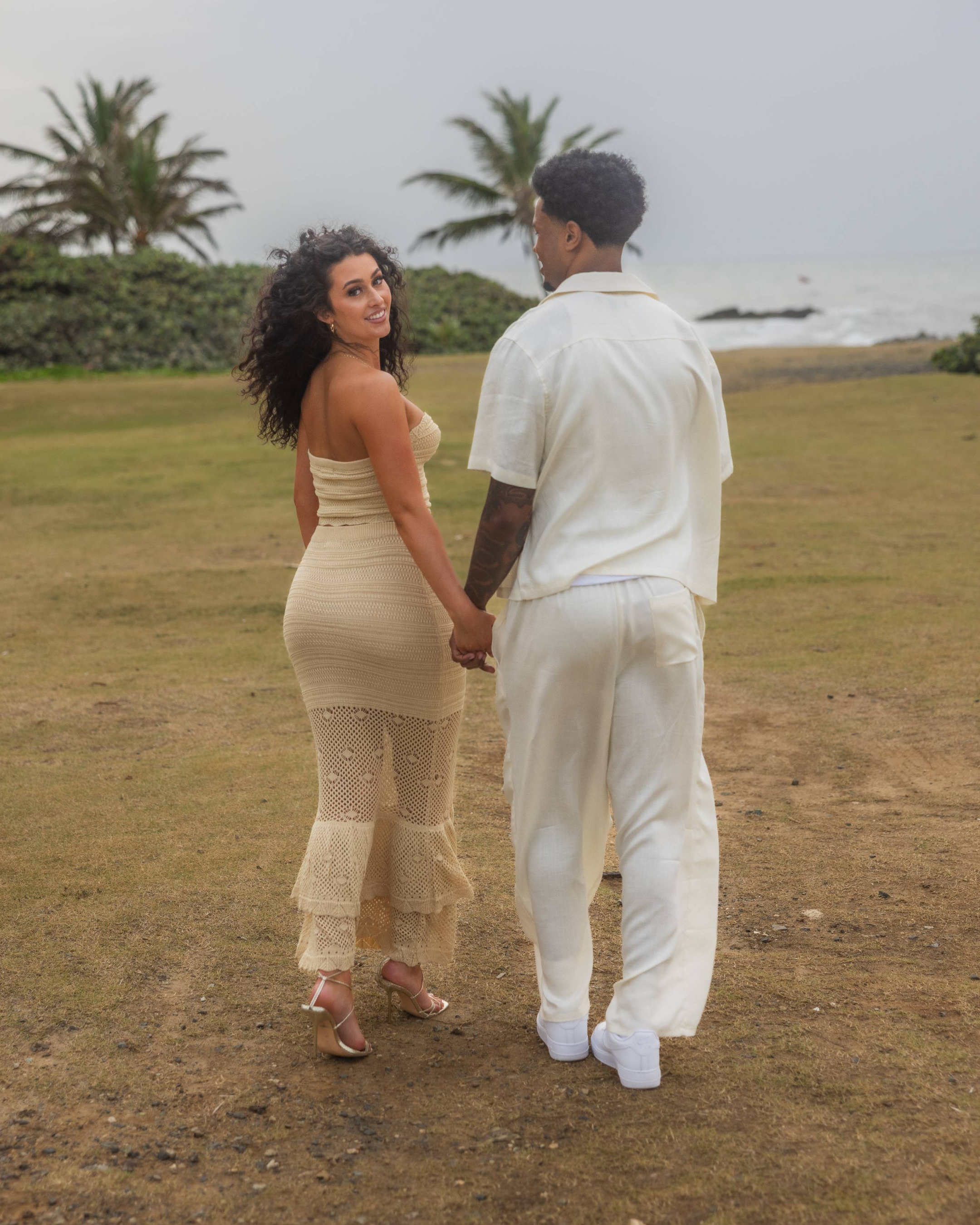 Recently engaged couple walks hand in hand along Escambrón Beach after a surprise marriage proposal in Puerto Rico.