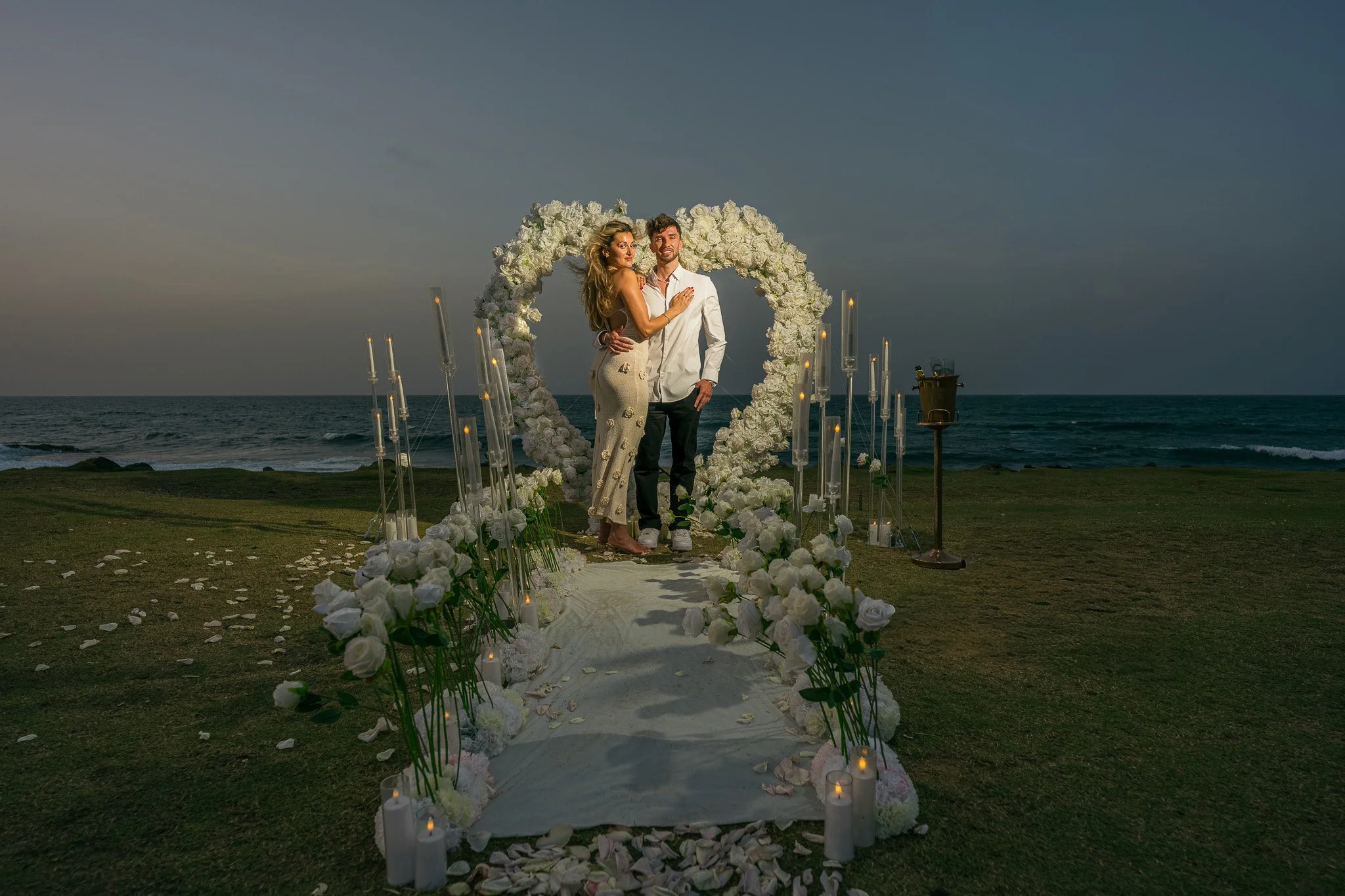 Editorial portrait of a couple in front of their marriage proposal decoration in Escambrón Beach during their engagement session in Puerto Rico