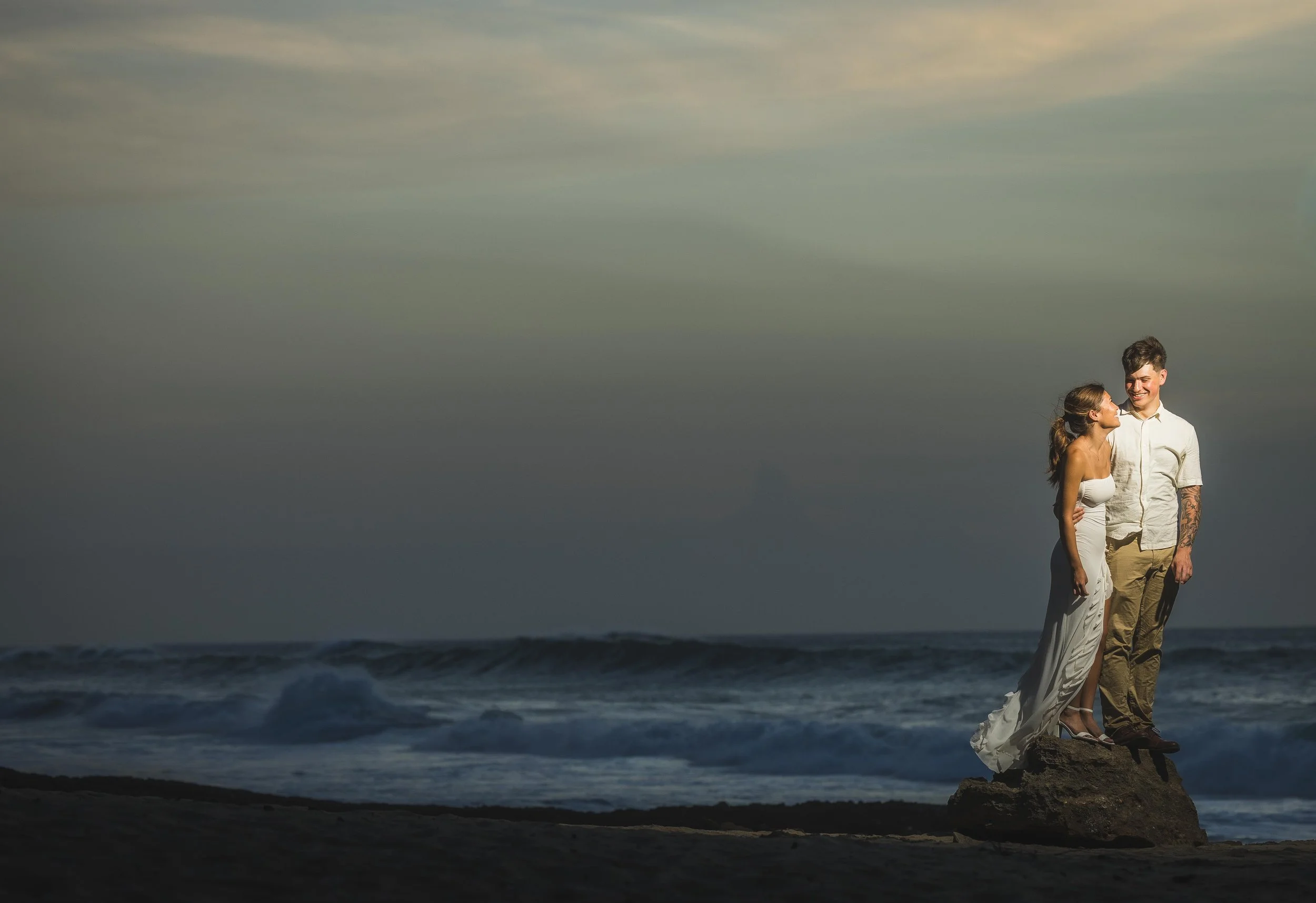 Flash portrait of a recently engaged couple during their marriage proposal at Punta Borinquen Beach taken by a wedding photographer in Puerto Rico