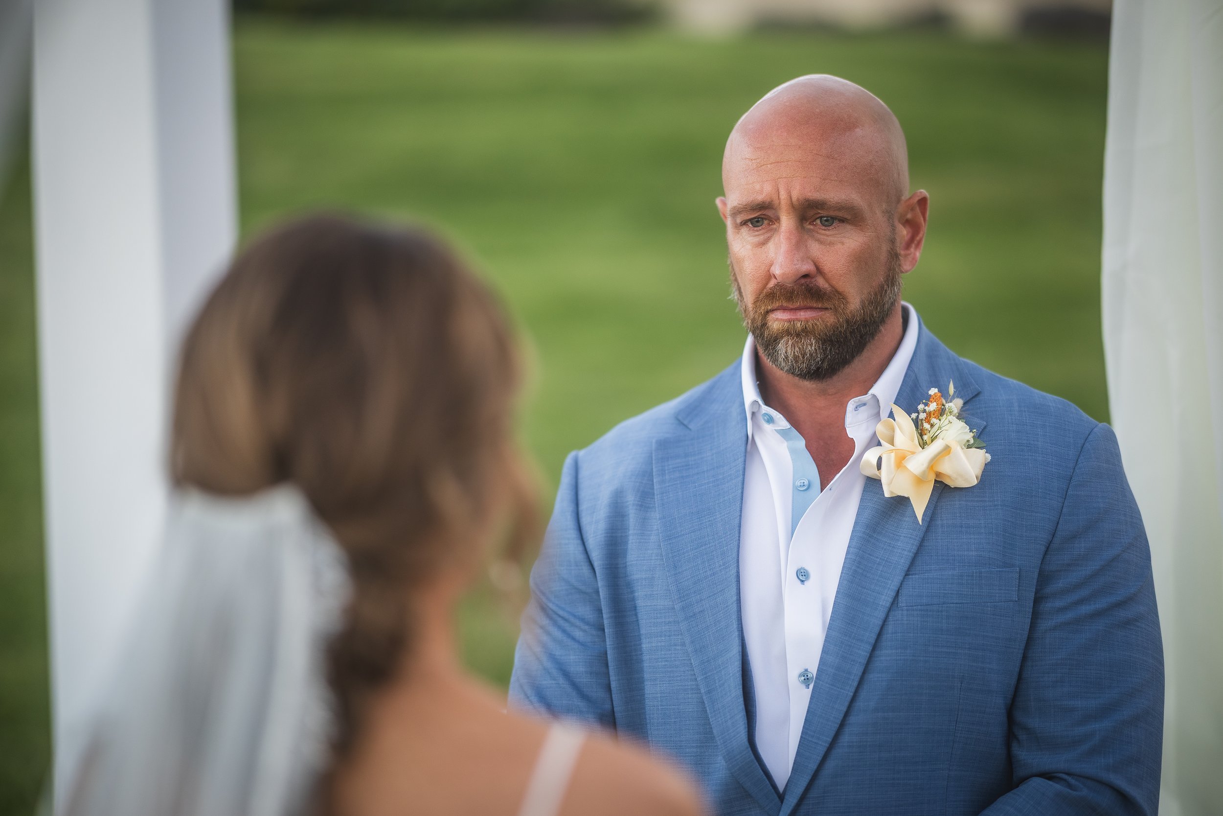 Groom listening to bride during ceremony at El Conquistador Resort taken by a Puerto Rico wedding photographer