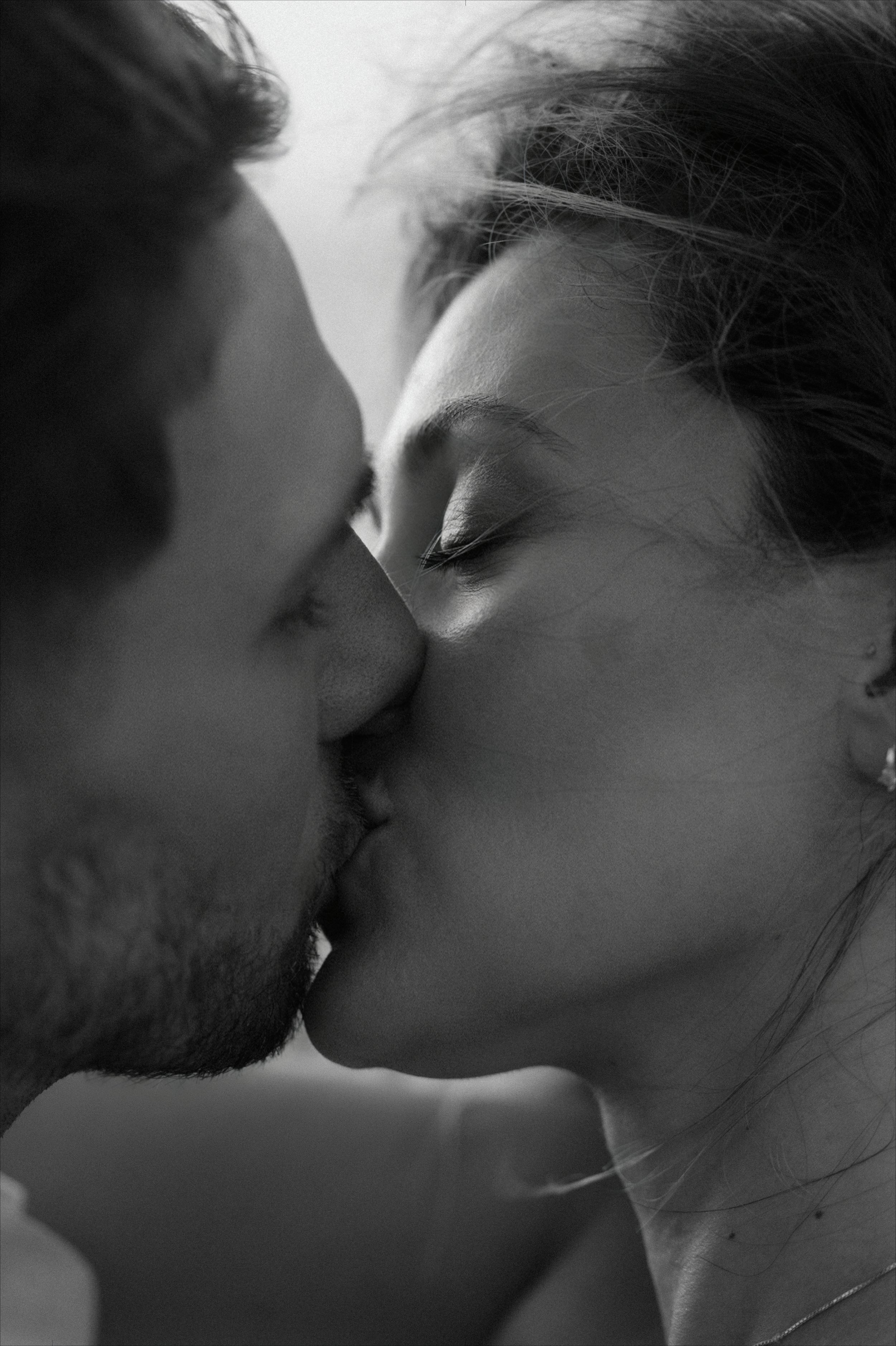 Editorial portrait of a couple kissing in Escambrón Beach during their marriage proposal engagement session in Puerto Rico