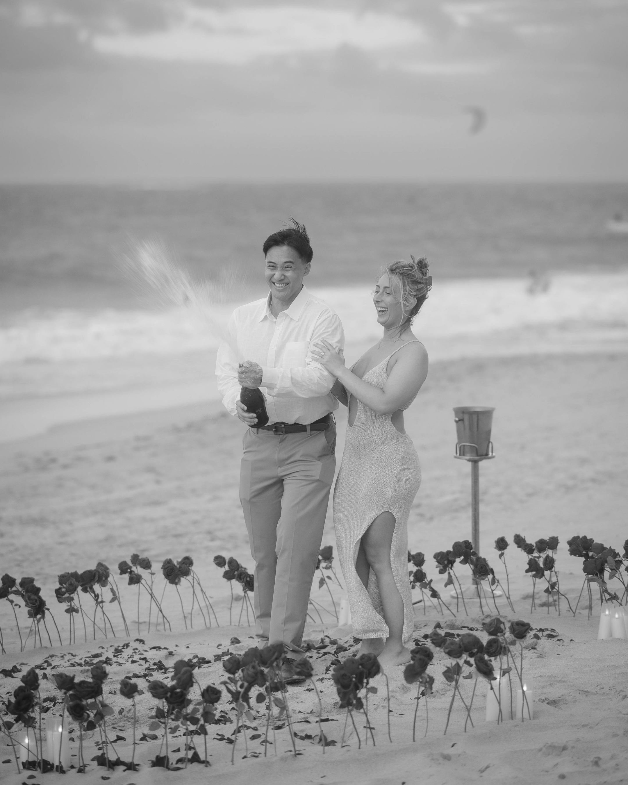 Couple opening a champagne bottle after their surprise marriage proposal in Puerto Rico.