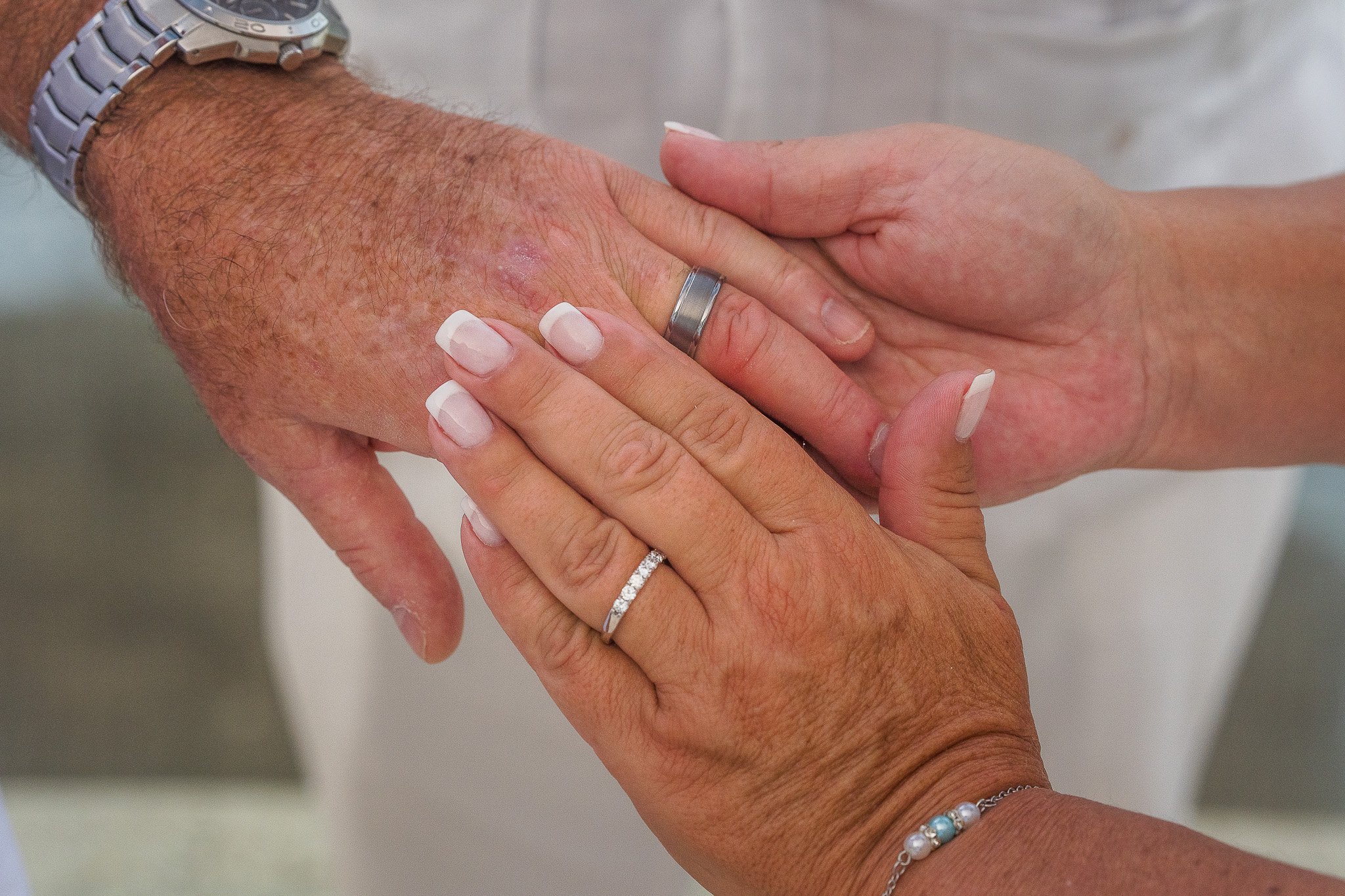 Bride & groom holding hands showing their engagement rings at the Condado Vanderbilt Hotel taken by a destination elopement photographer in Puerto Rico