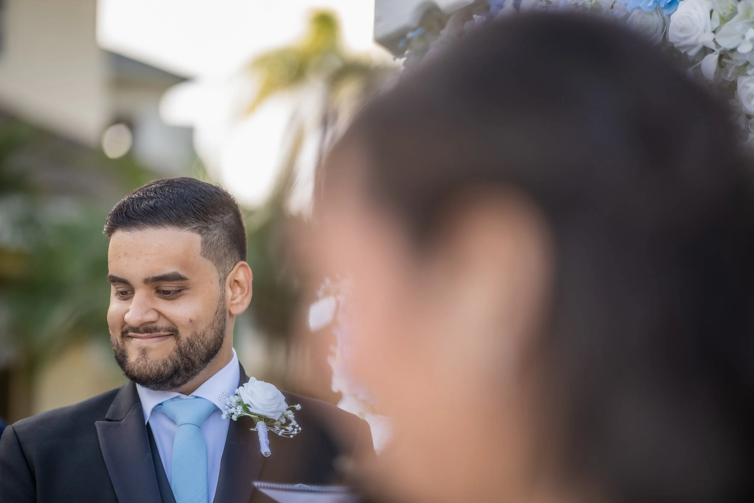 Groom listening to bride's vows during their luxury wedding ceremony at Indian Spring Country Club in Boynton Beach, Florida.