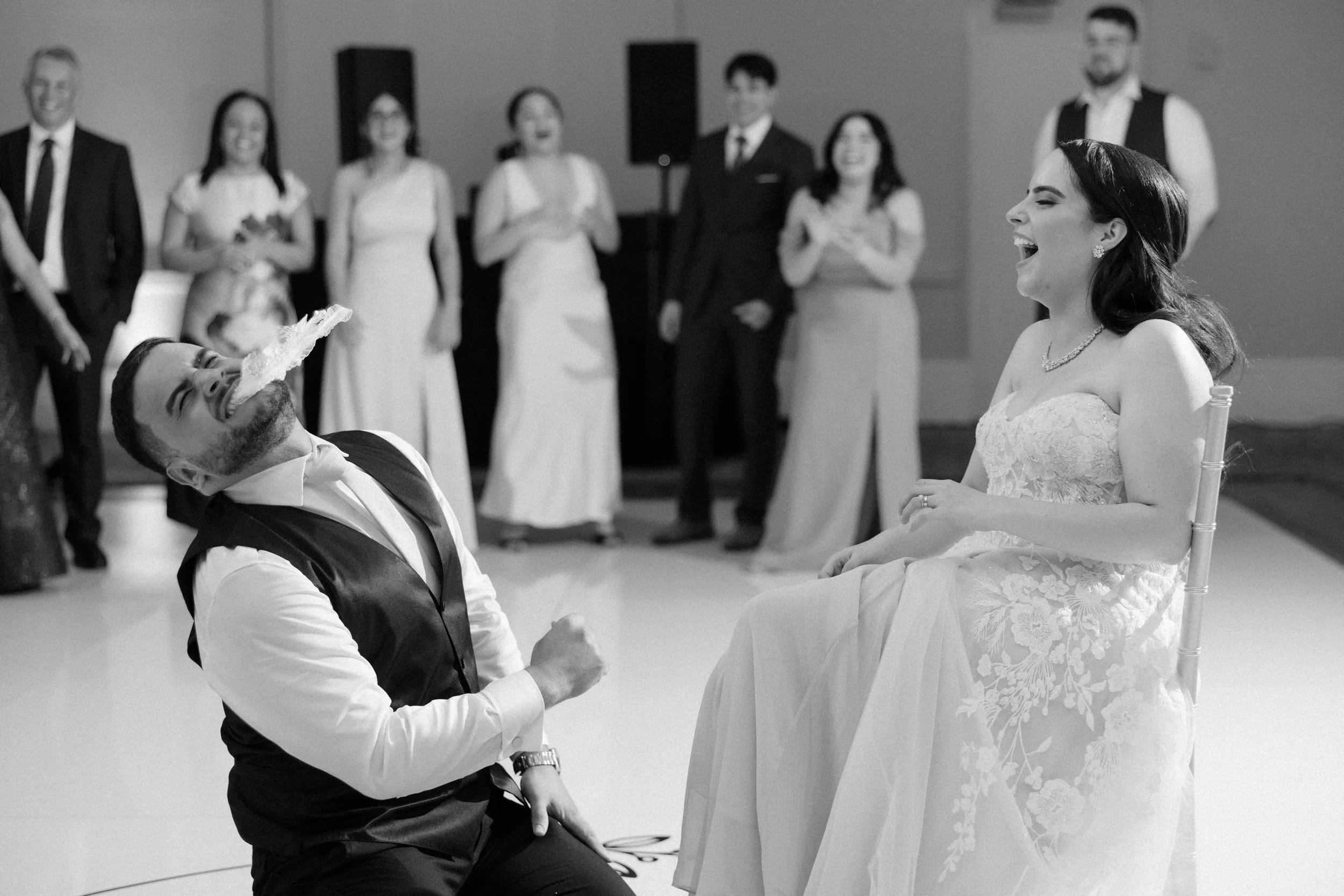 Groom with garter belt in mouth during the reception of his luxury wedding at Indian Spring Country Club in Boynton Beach, Florida