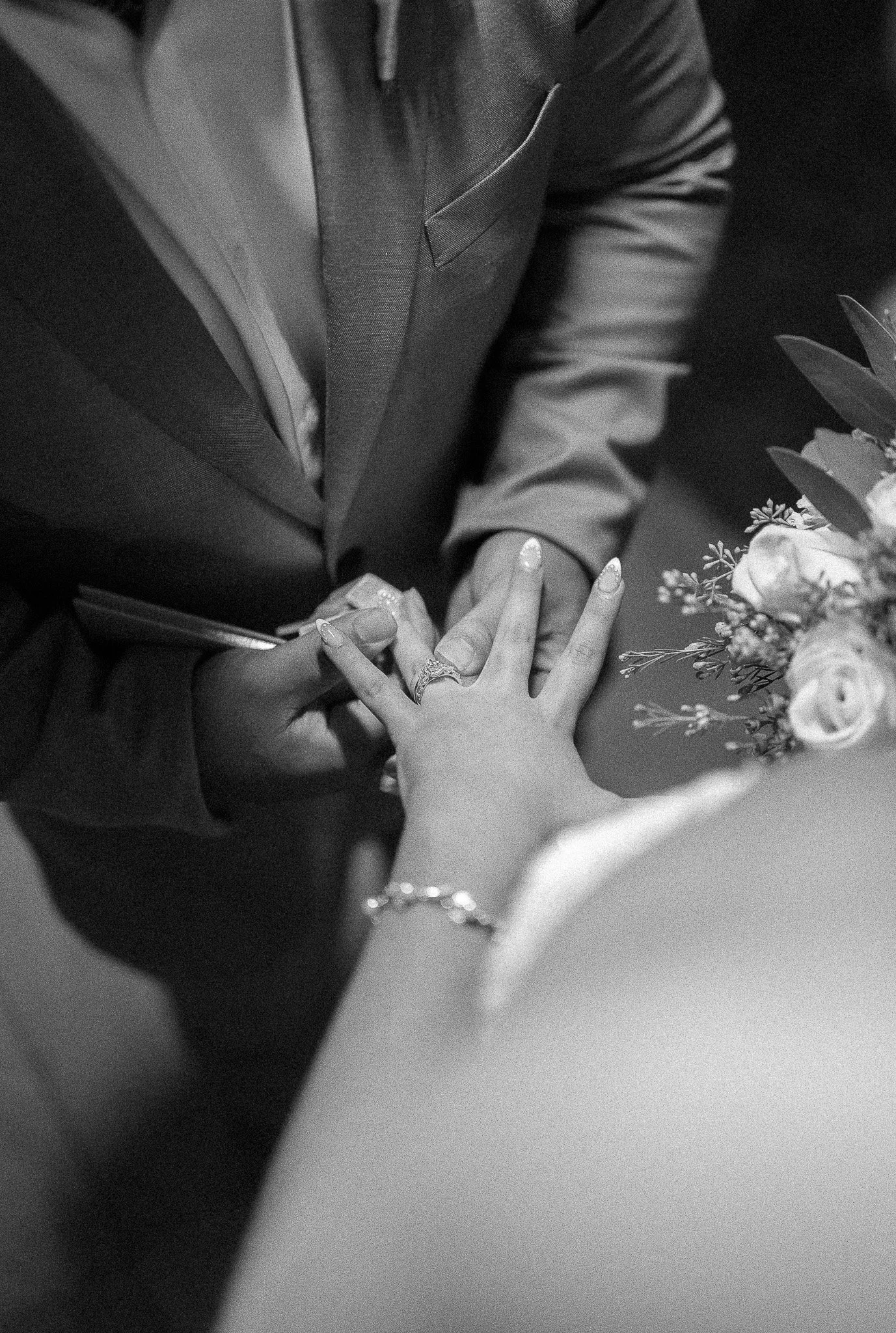 Editorial black and white portrait of a bride and groom exchanging rings during their elopement wedding in Puerto Rico