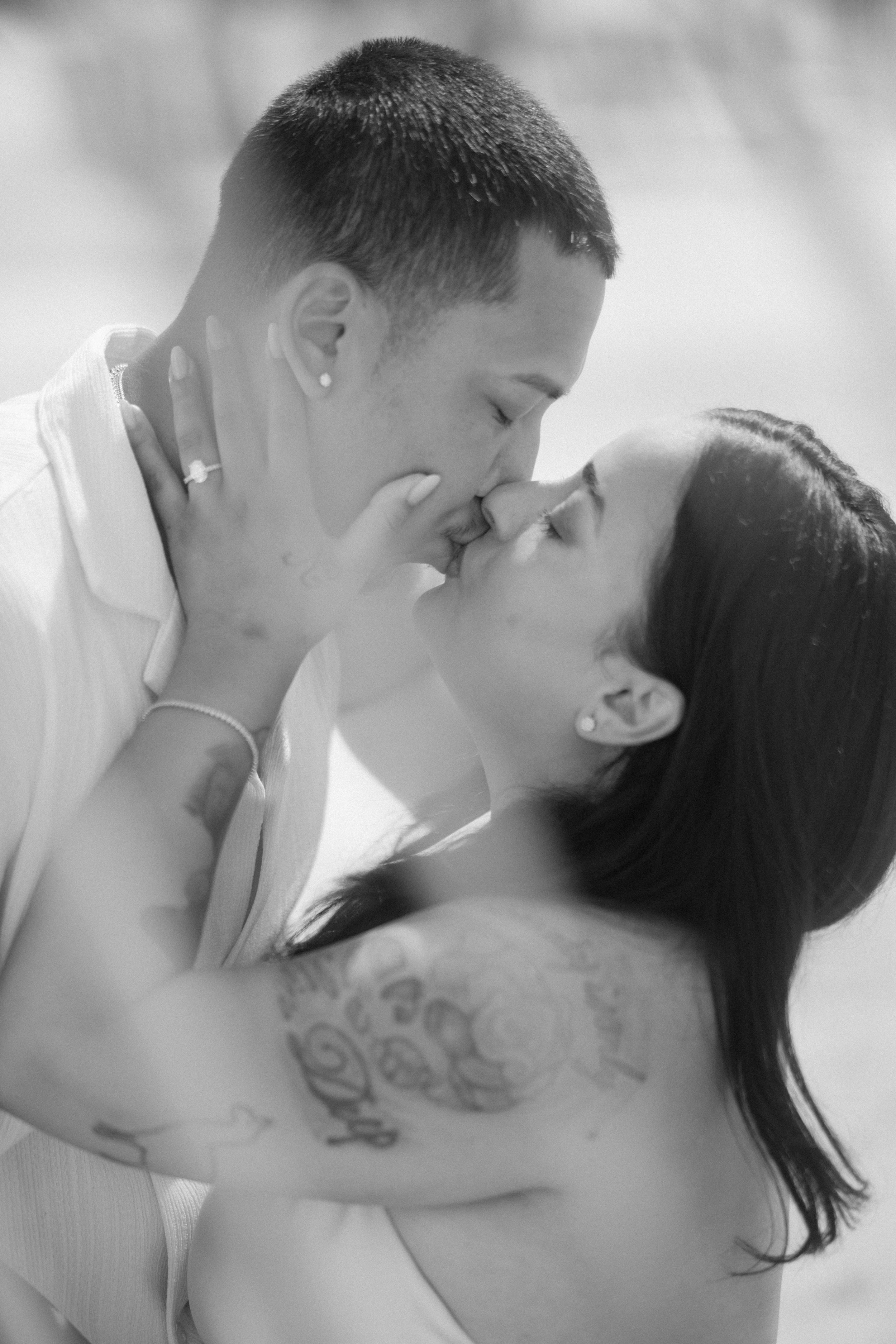 Newly engaged couple celebrating after surprise proposal during relaxed engagement photo session outdoors.