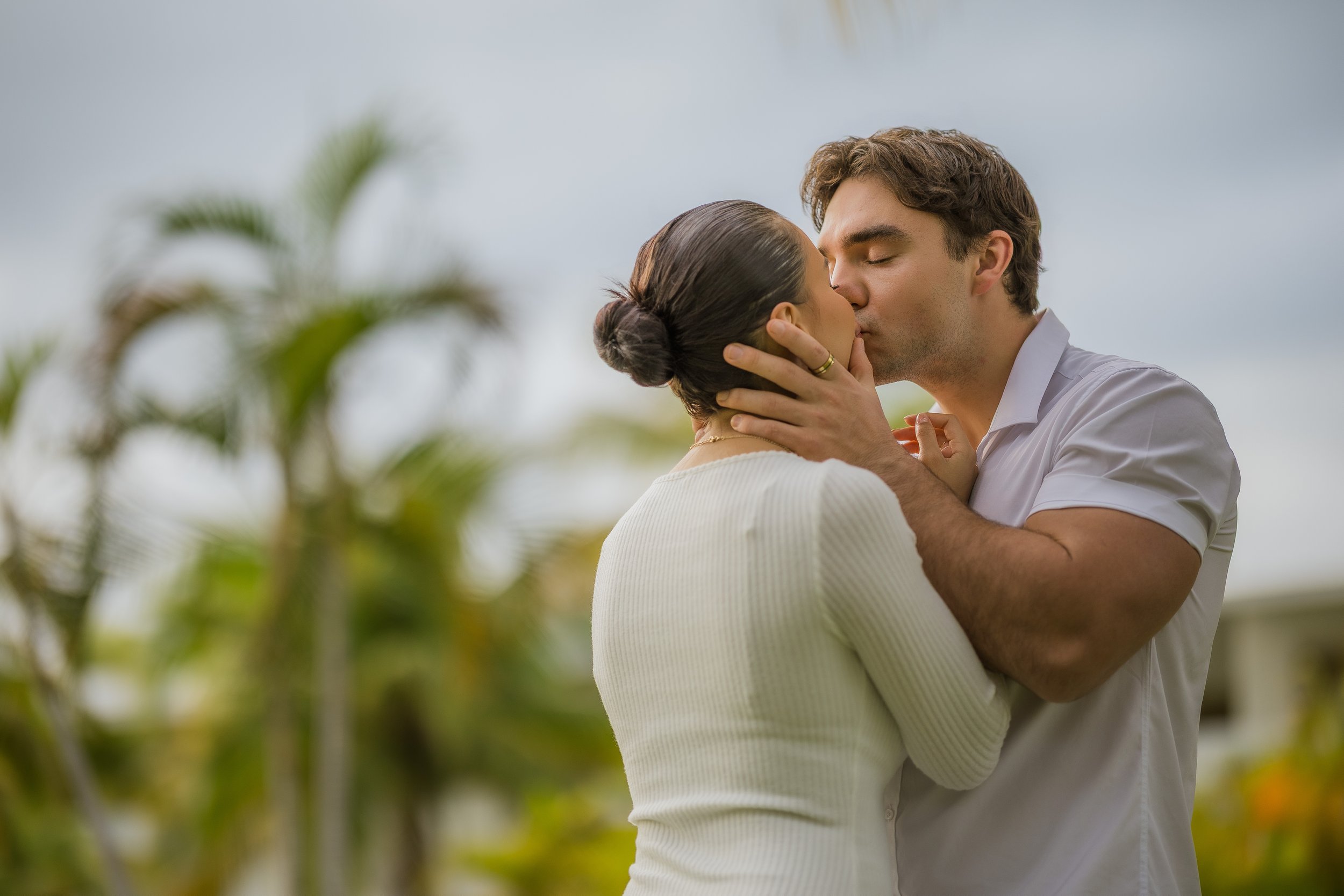 Couple kissing during a maternity photoshoot turned marriage proposal at the Hyatt Regency Grand Reserve in Puerto Rico