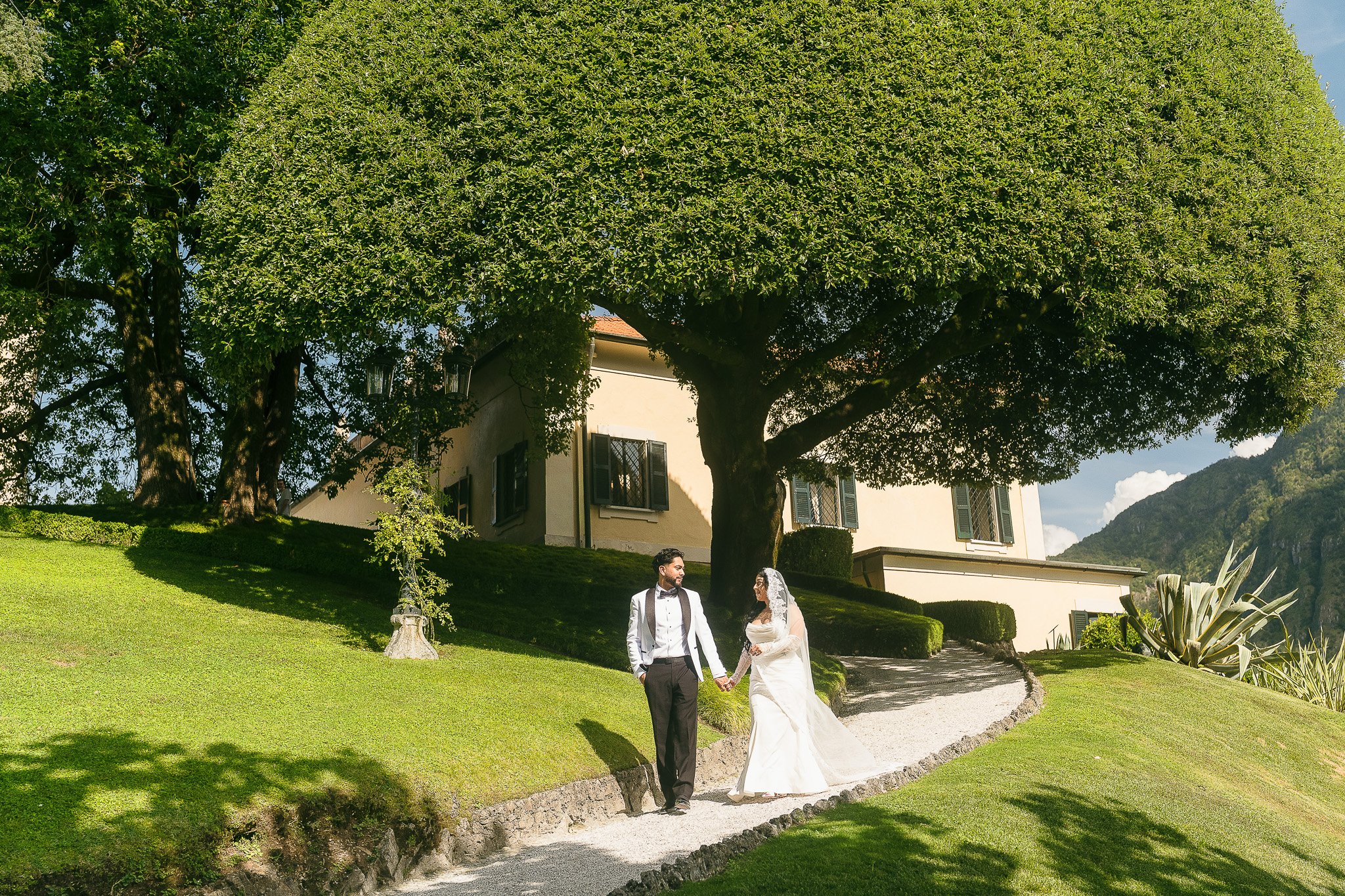 Bride and groom holding hands at Villa del Balbianello, a luxury wedding venue in Lake Como, Italy shot by a destination wedding photographer