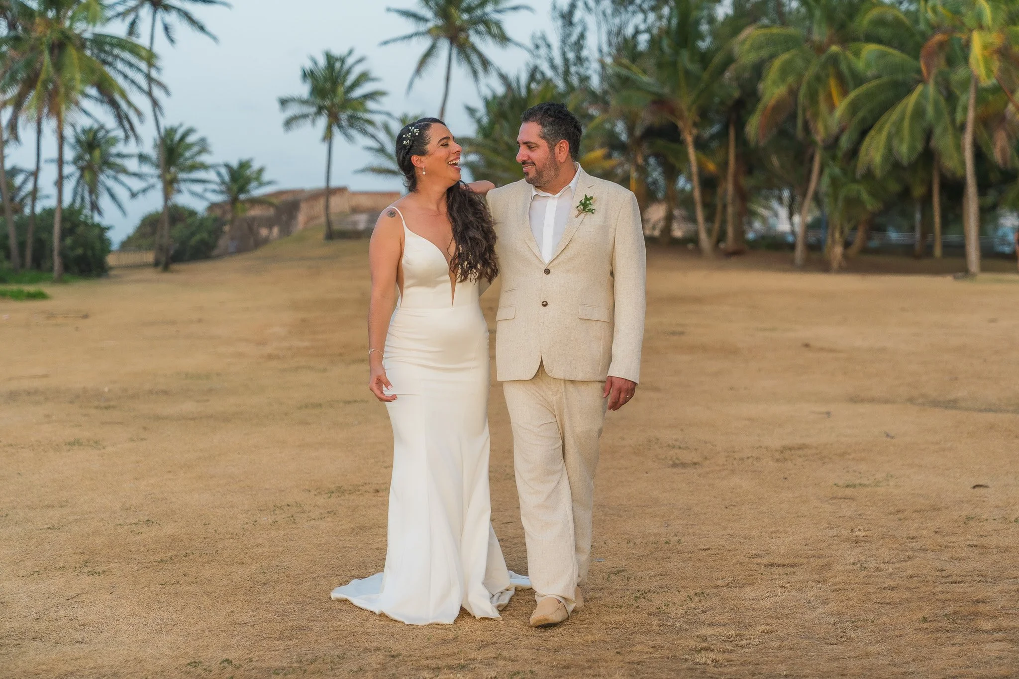 Newly married couple walking along Escambrón Beach after their ceremony