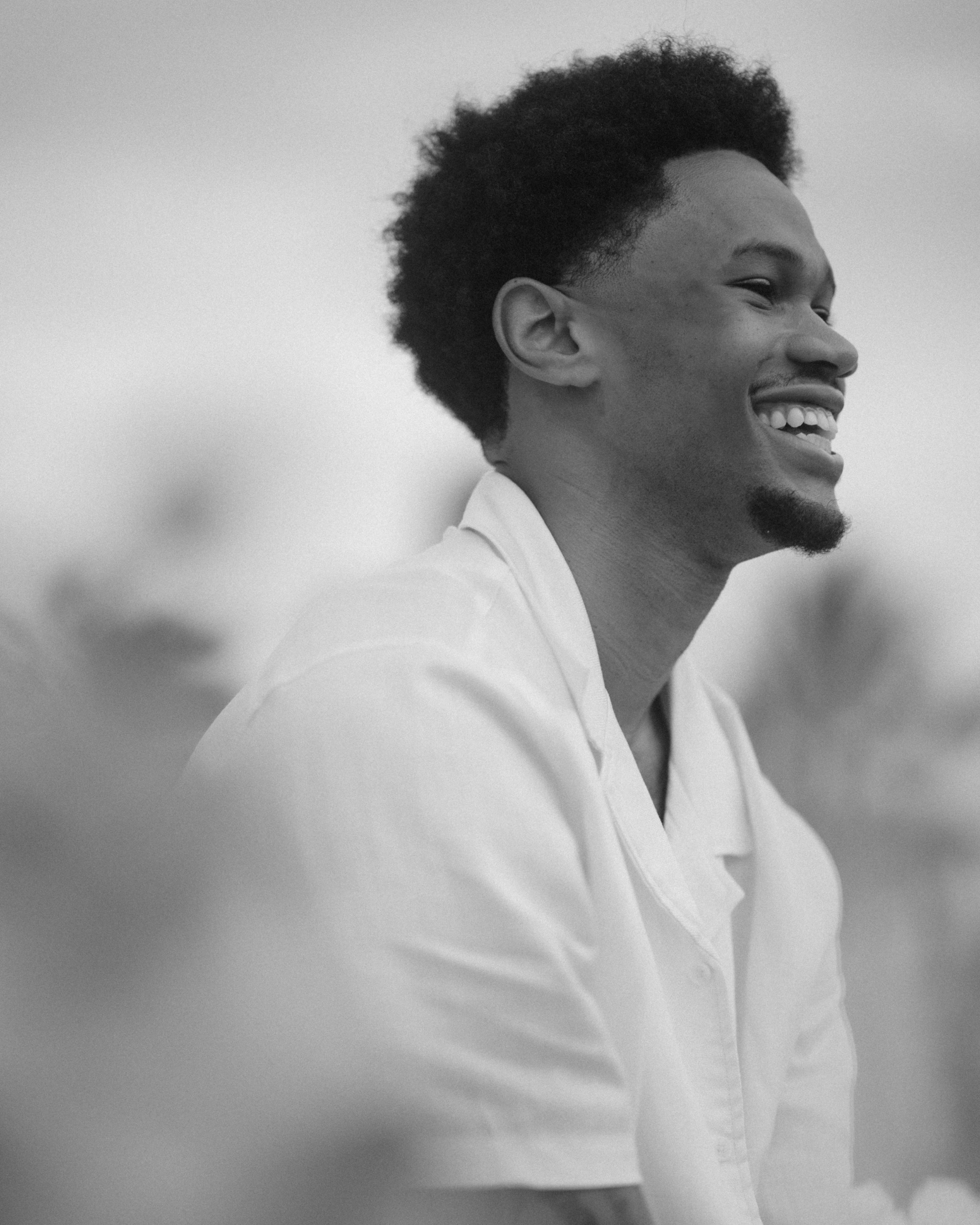 Professional basketball player Zeb Jackson laughing during a romantic beachfront engagement portrait session in Puerto Rico.