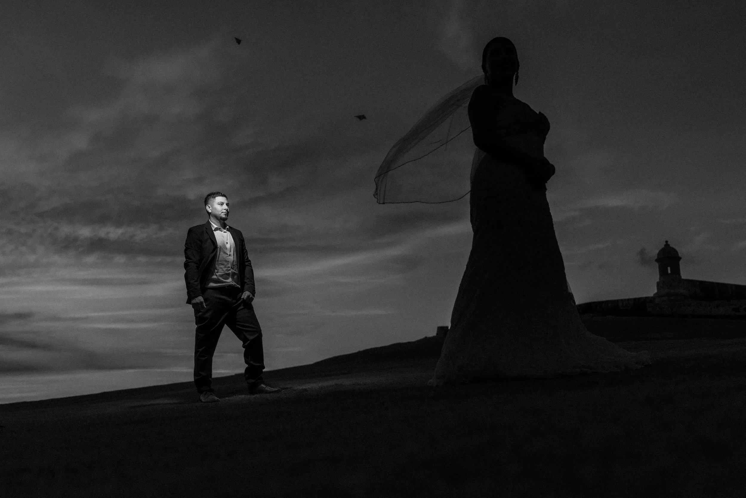 Bride and groom posing together at twilight overlooking the Caribbean Sea after their luxury destination elopement in Old San Juan, Puerto Rico.