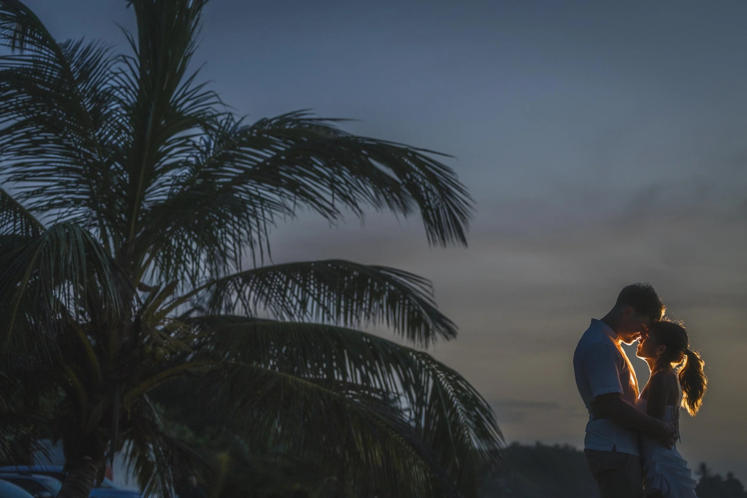 Man and woman in sweet embrace during Golden Hour after their engagement session in Punta Borinquen Beach taken by a wedding photographer in Puerto Rico