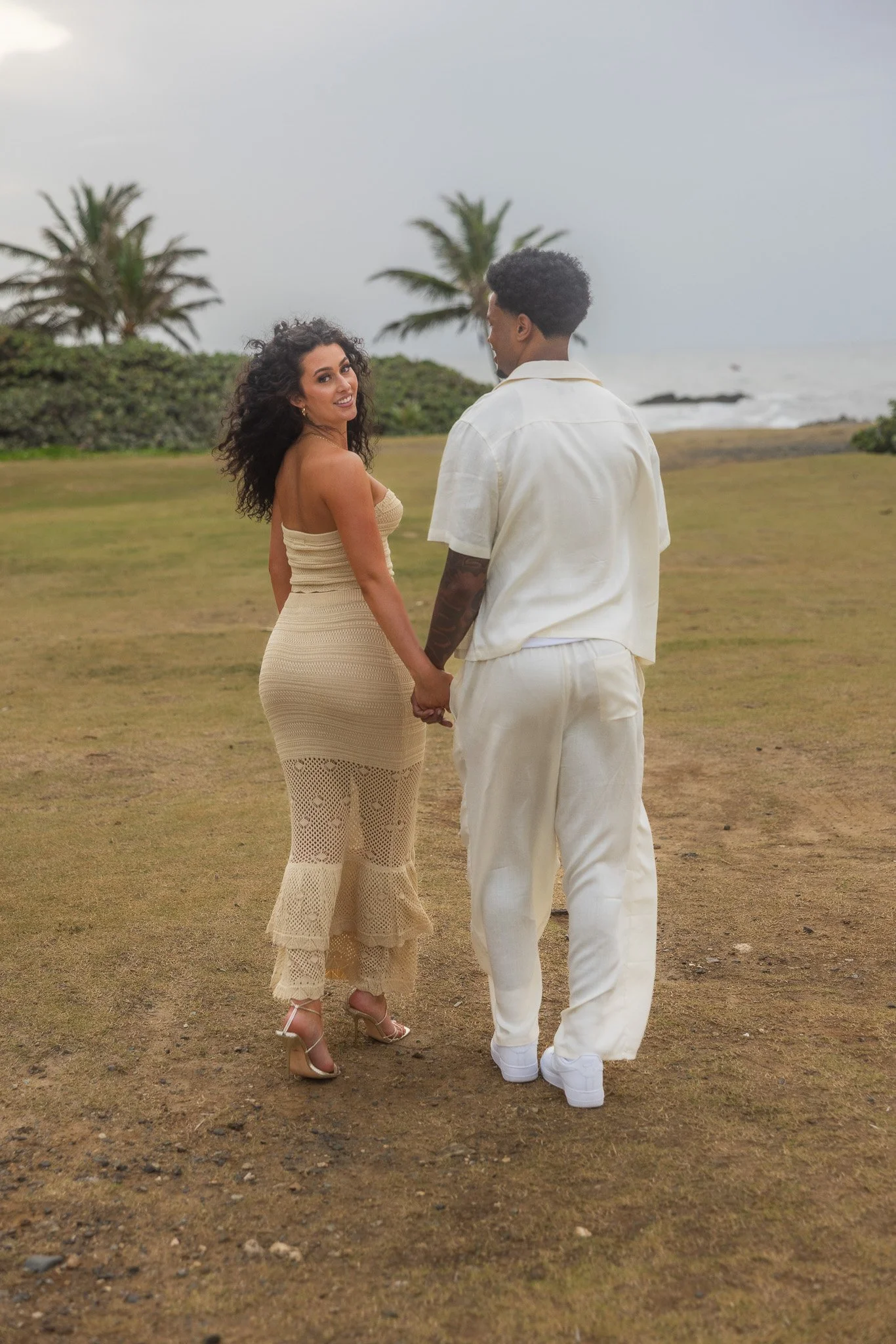Couple holding hands during the engagement session following a surprise marriage proposal in Puerto Rico taken by a luxury wedding photographer