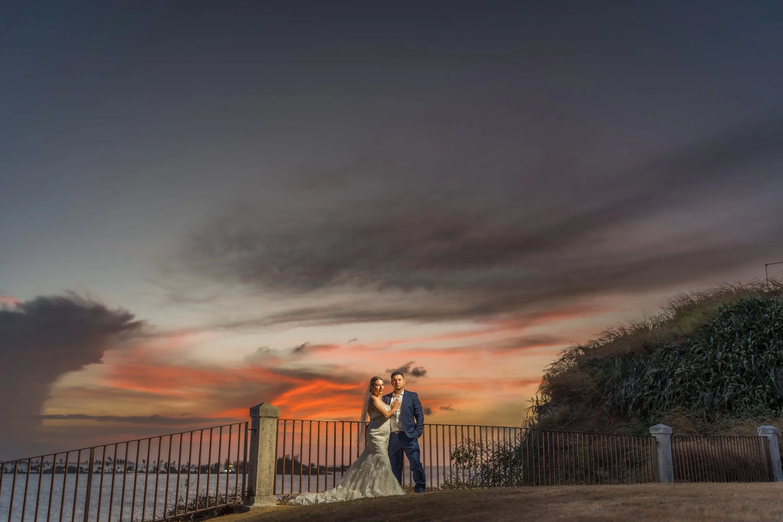 Bride and groom posing together at twilight overlooking the Caribbean Sea after their luxury destination elopement in Old San Juan, Puerto Rico.