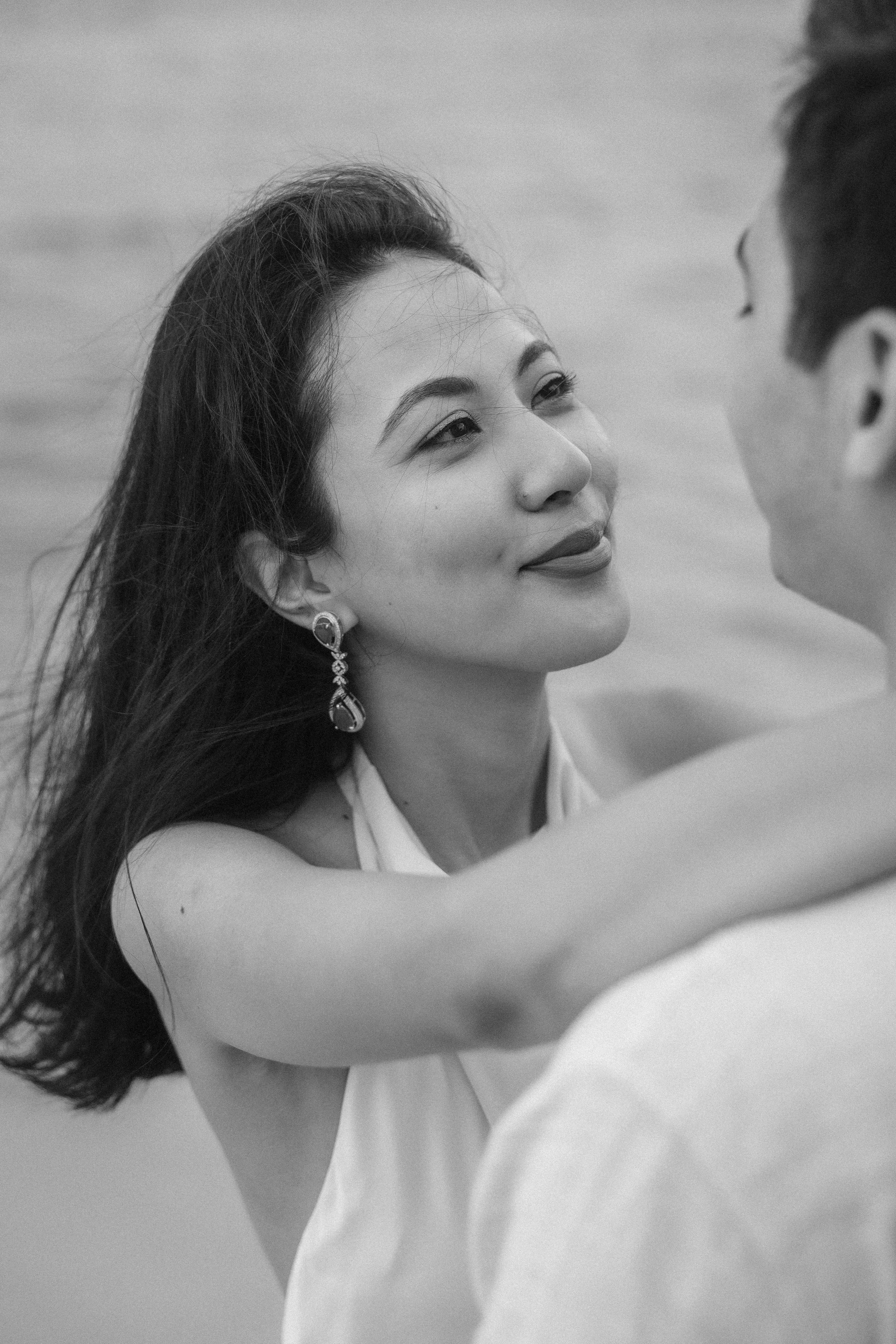 Editorial black and white portrait of Sumi looking lovingly at Brijend during their romantic beach engagement session in Puerto Rico.