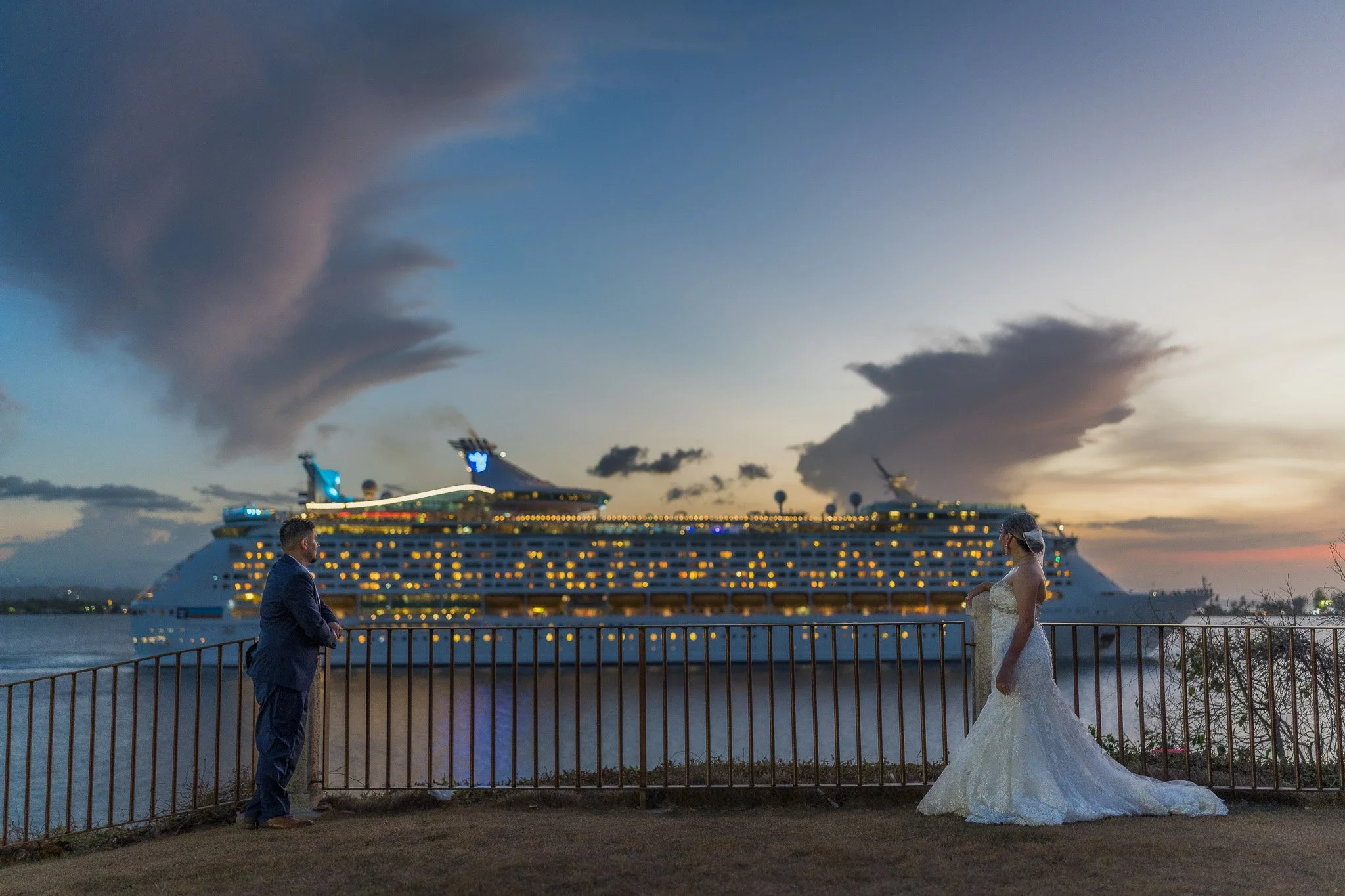 Bride and groom sharing a quiet moment overlooking a cruise ship at sunset during their destination elopement in Old San Juan, Puerto Rico.