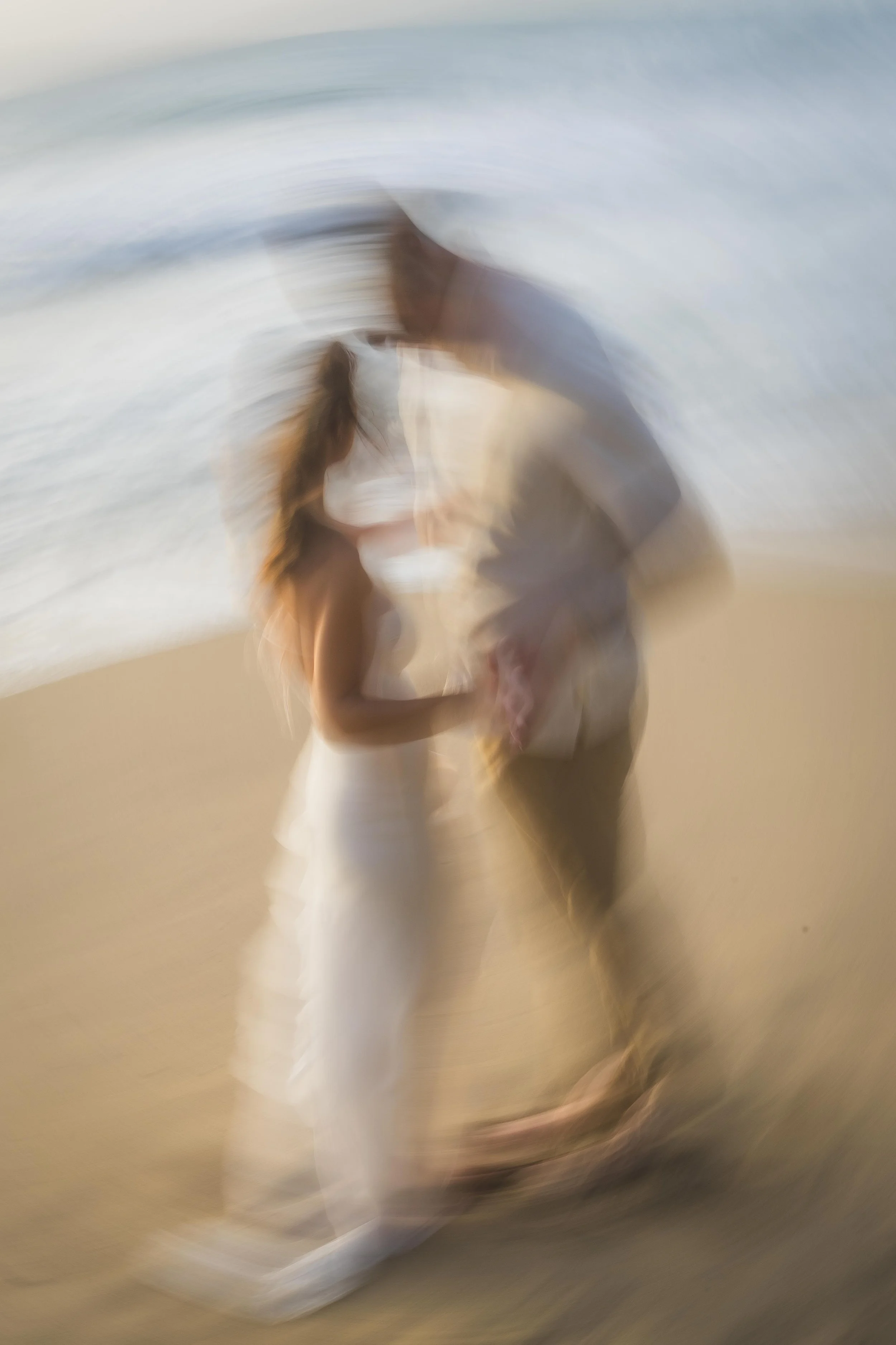 Trendy, blurry portrait of a newly engaged couple at Punta Borinquen Beach taken by a marriage proposal photographer in Puerto Rico
